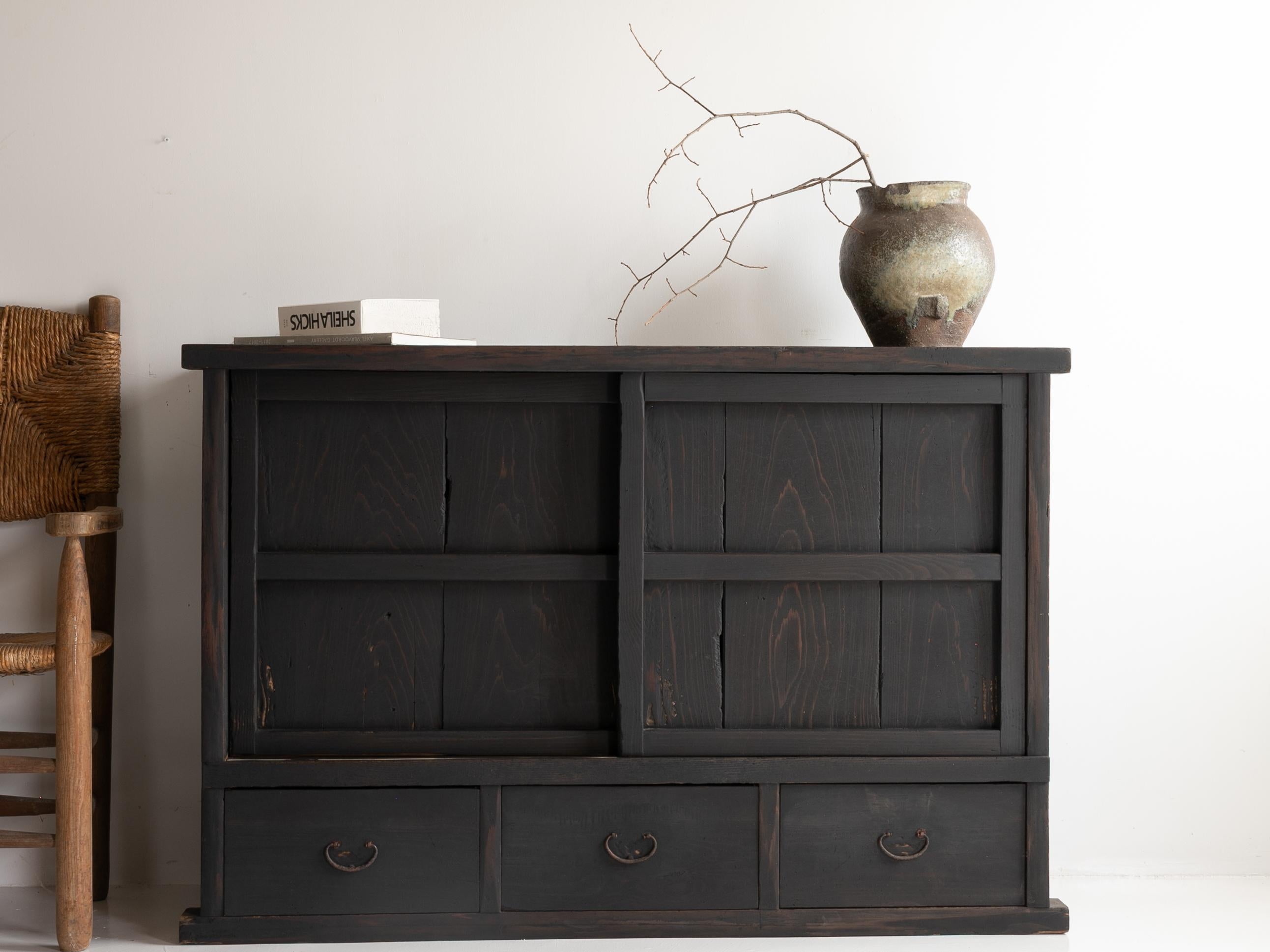This is a historically significant Japanese tansu (chest) from the Meiji era (1860s–1900s), crafted from cedar wood.

Its minimalist and refined design embodies traditional Japanese aesthetics. The lattice sliding doors create an interplay of light