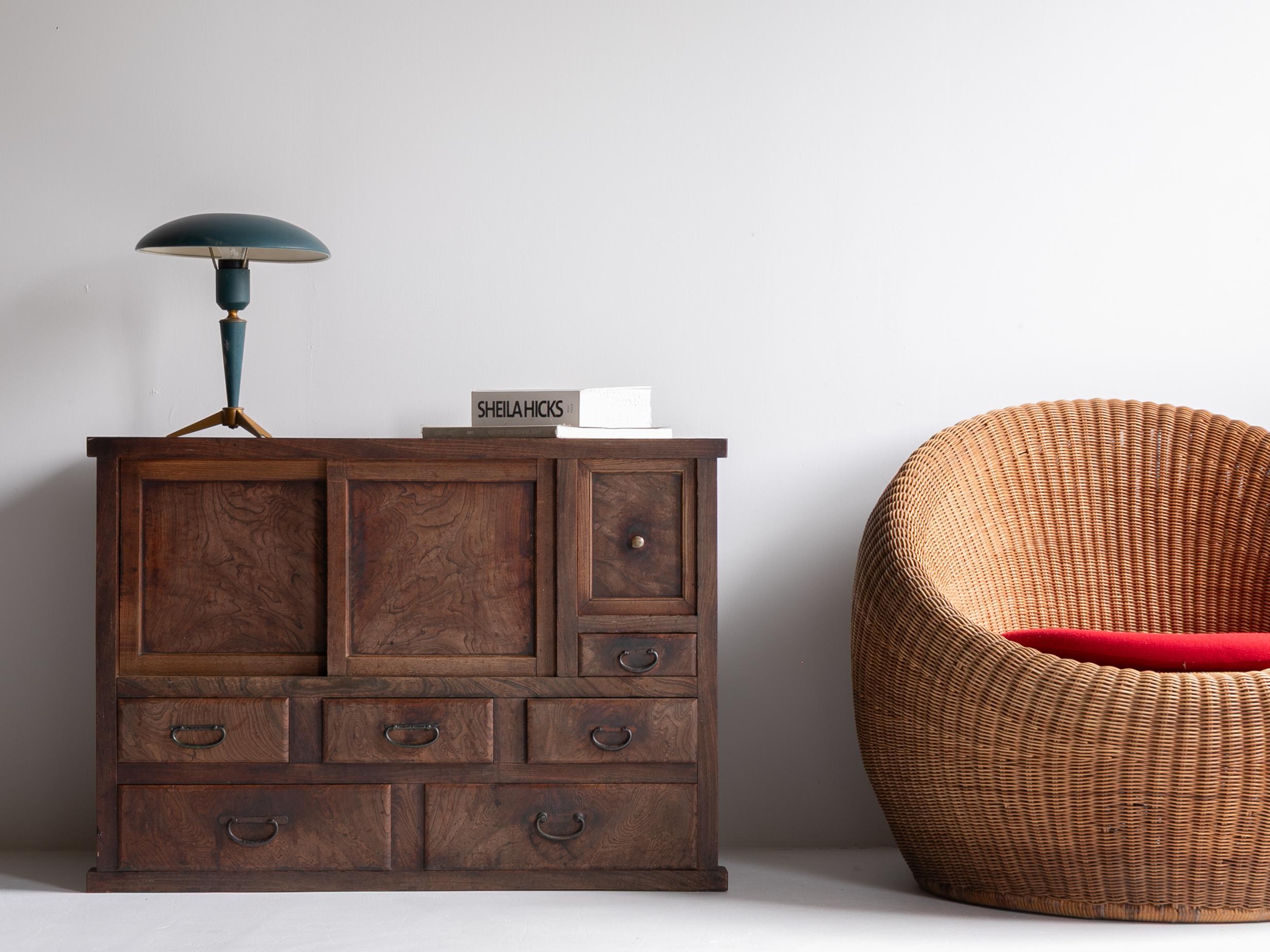 A refined Cha-dansu (tea cabinet) crafted in Japan during the Taishō to early Shōwa period, made from richly grained keyaki (zelkova) wood. The cabinet features a striking natural grain pattern that flows beautifully across the sliding doors and