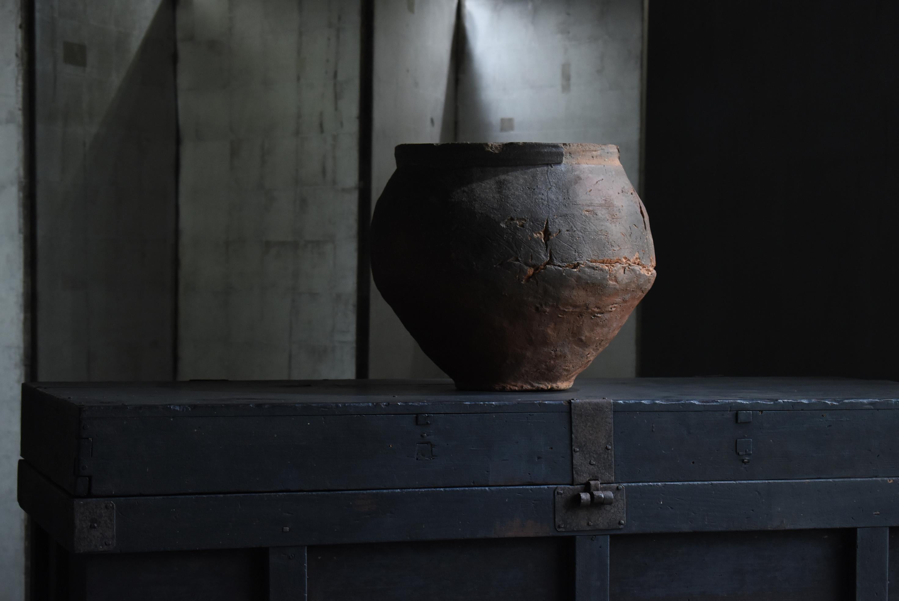 This is a very old Japanese Pottery vase.
It is called Tokoname in Japan.
This vase was made in the 14th century.

The distorted shape, formed by hand, is rather beautiful.
Cracks can be seen, but even these are a part of the scenery.

Although
