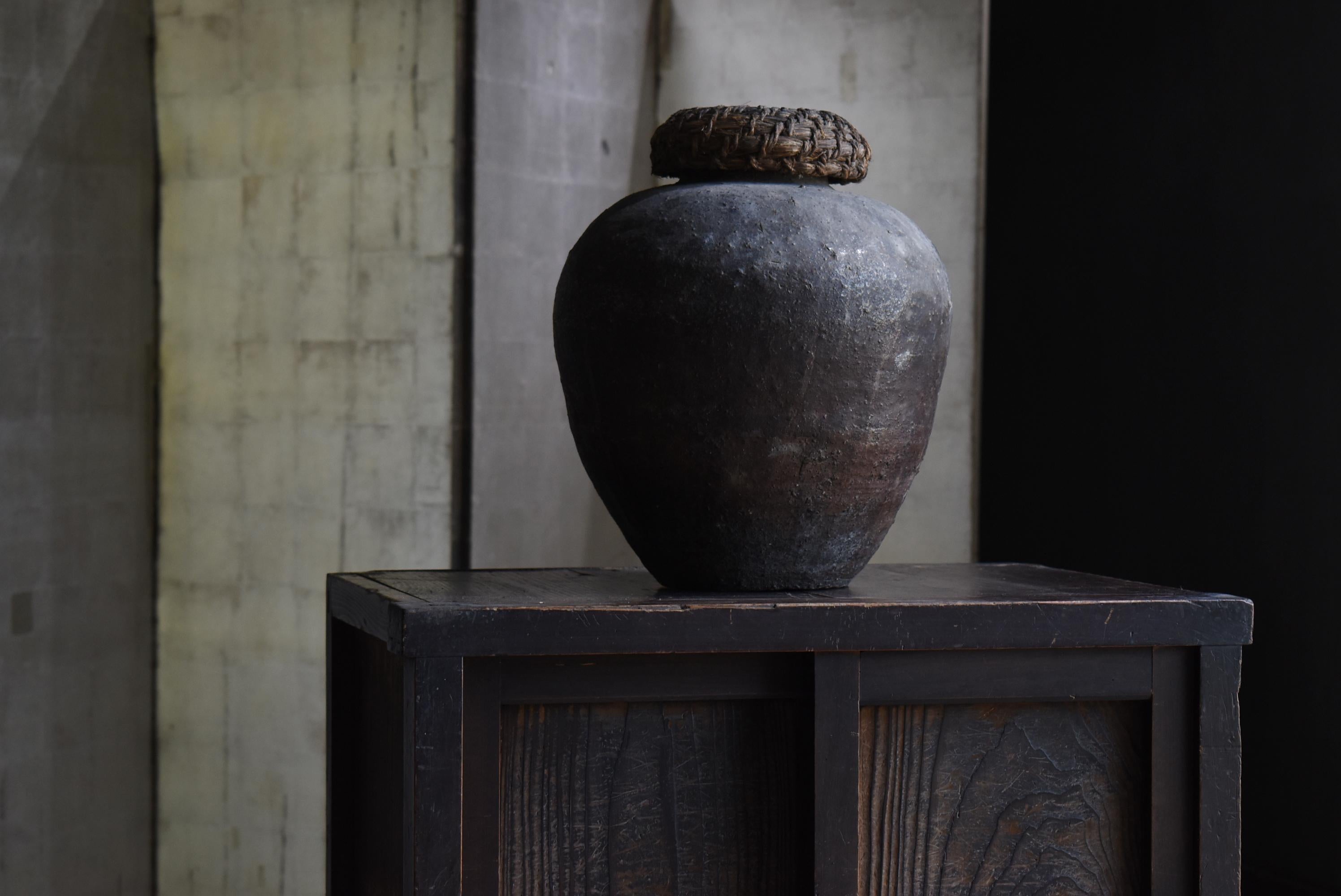 Very old Japanese pottery pot.
It is called Shigaraki ware.
It dates from the Edo period (1800s-1860s).
The lid is made of straw.

This jar was used to store tea leaves.
It has a very unique and snarled shape.
It is a beautiful sight from any
