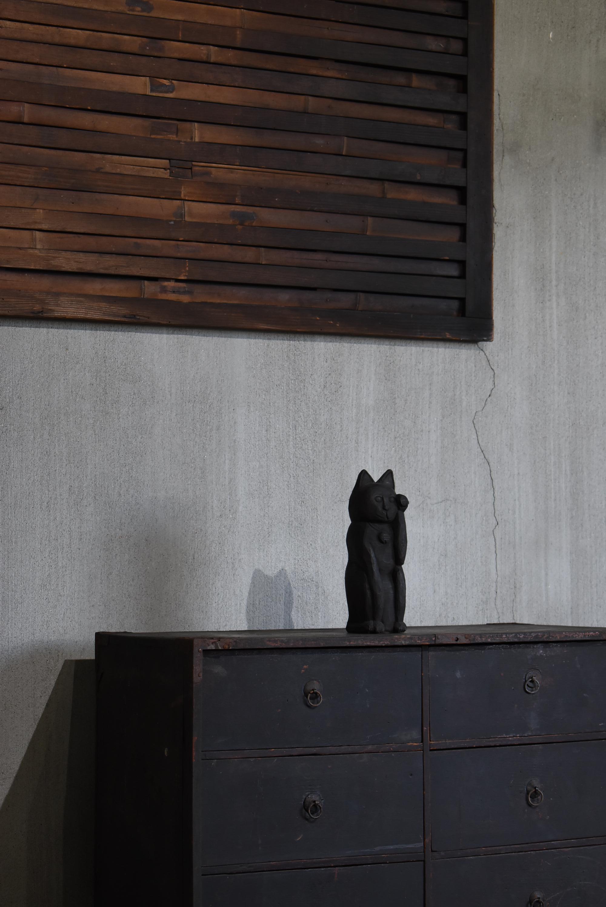 This is an old Japanese black beckoning cat wood carving.
It is estimated to be a wood carving from the early Showa period (1900s-1940s).
The material is believed to be paulownia wood.

It is carved entirely by hand.

It has long been popular