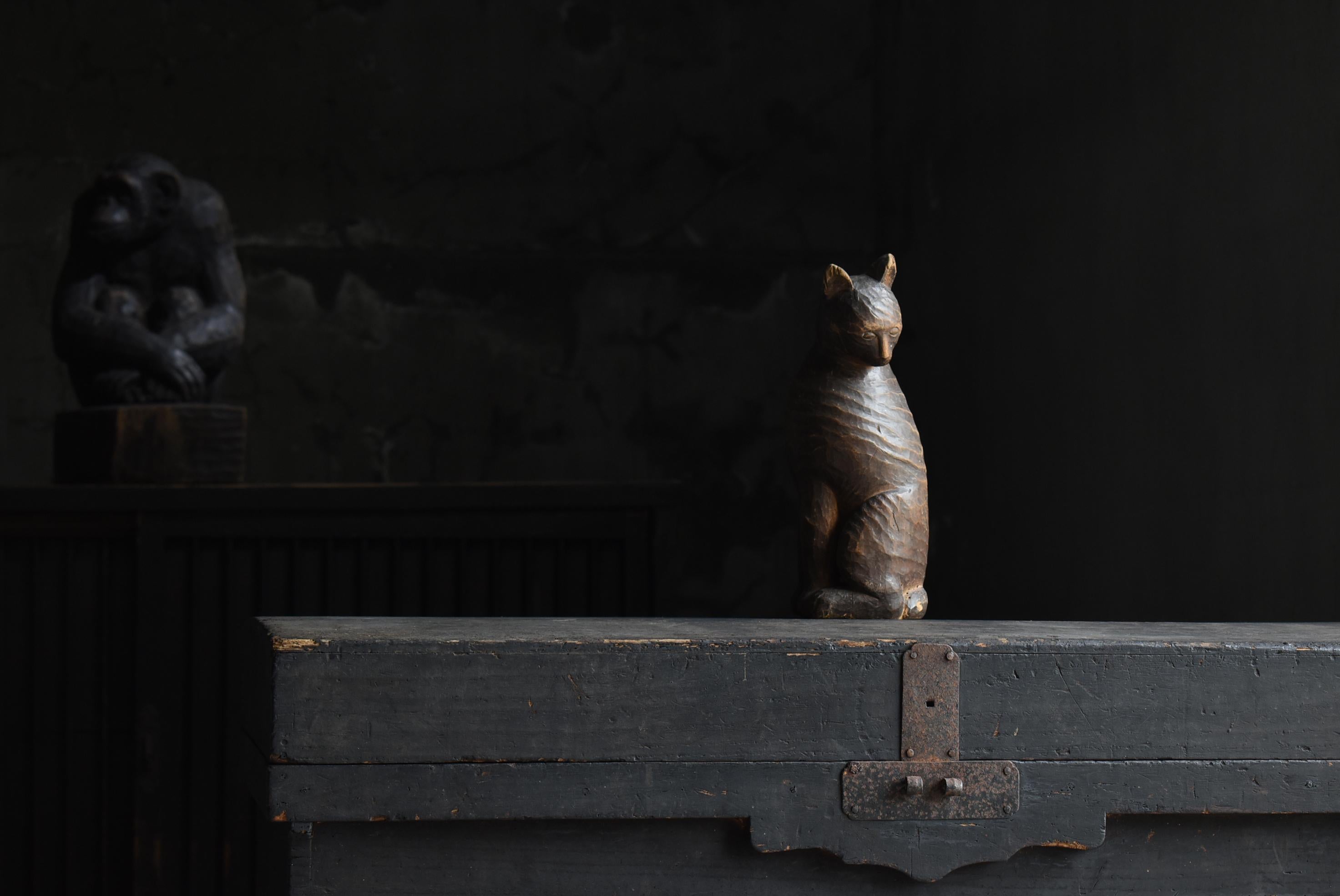 This is a very old carved wooden cat made in Japan.
It is from the Meiji period (1860s-1900s).
The material is probably pine.

It is a superb wood carving that captures the moment of a seated cat looking back.
It is a gem that conveys a lovely