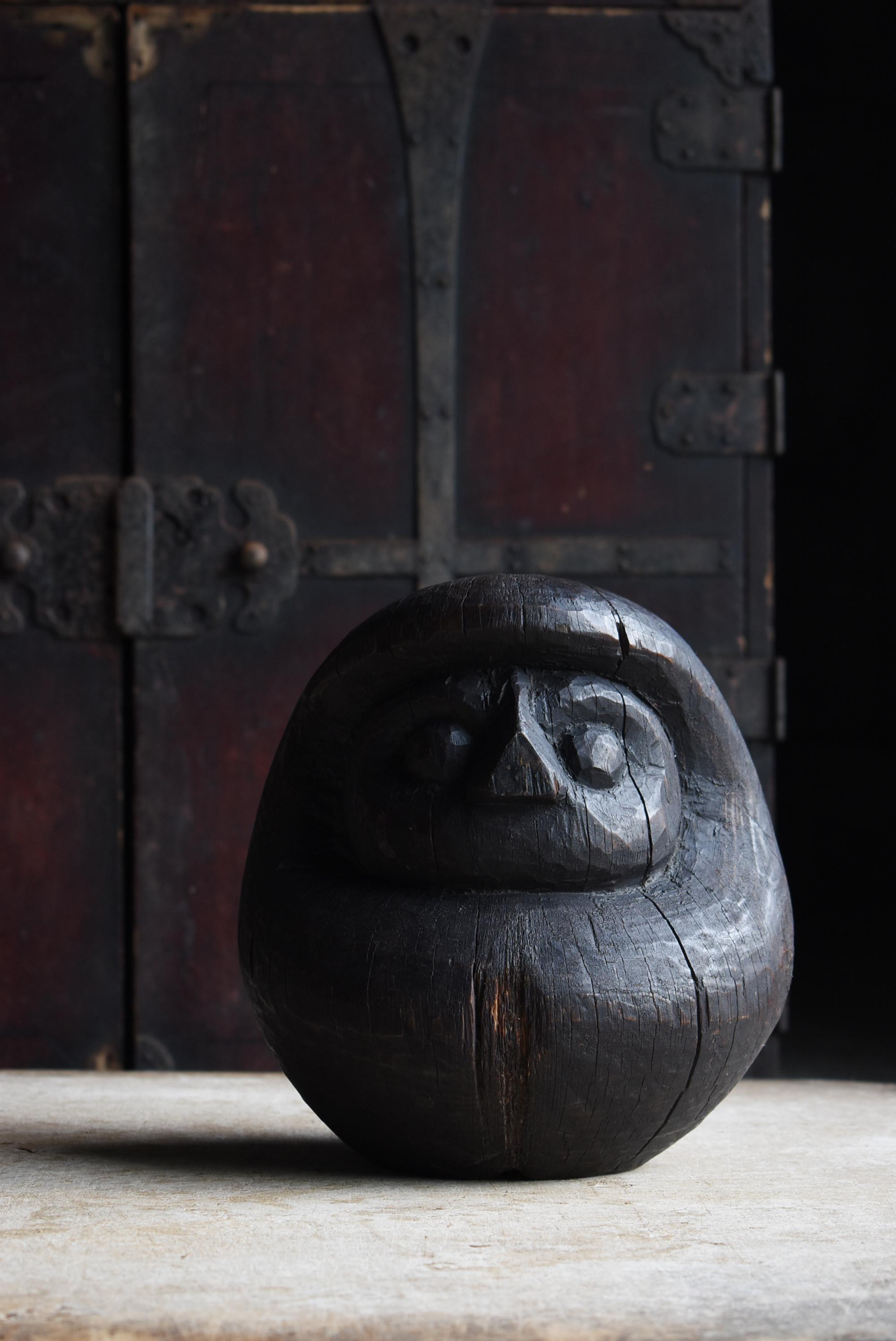 Il s'agit d'une ancienne forme en bois de Daruma fabriquée au Japon.
On estime qu'il a été fabriqué entre les périodes Meiji et Taisho (1860-1920) et semble avoir été fait en bois de cèdre.
Les profondes fissures et les teintes noires de suie dues