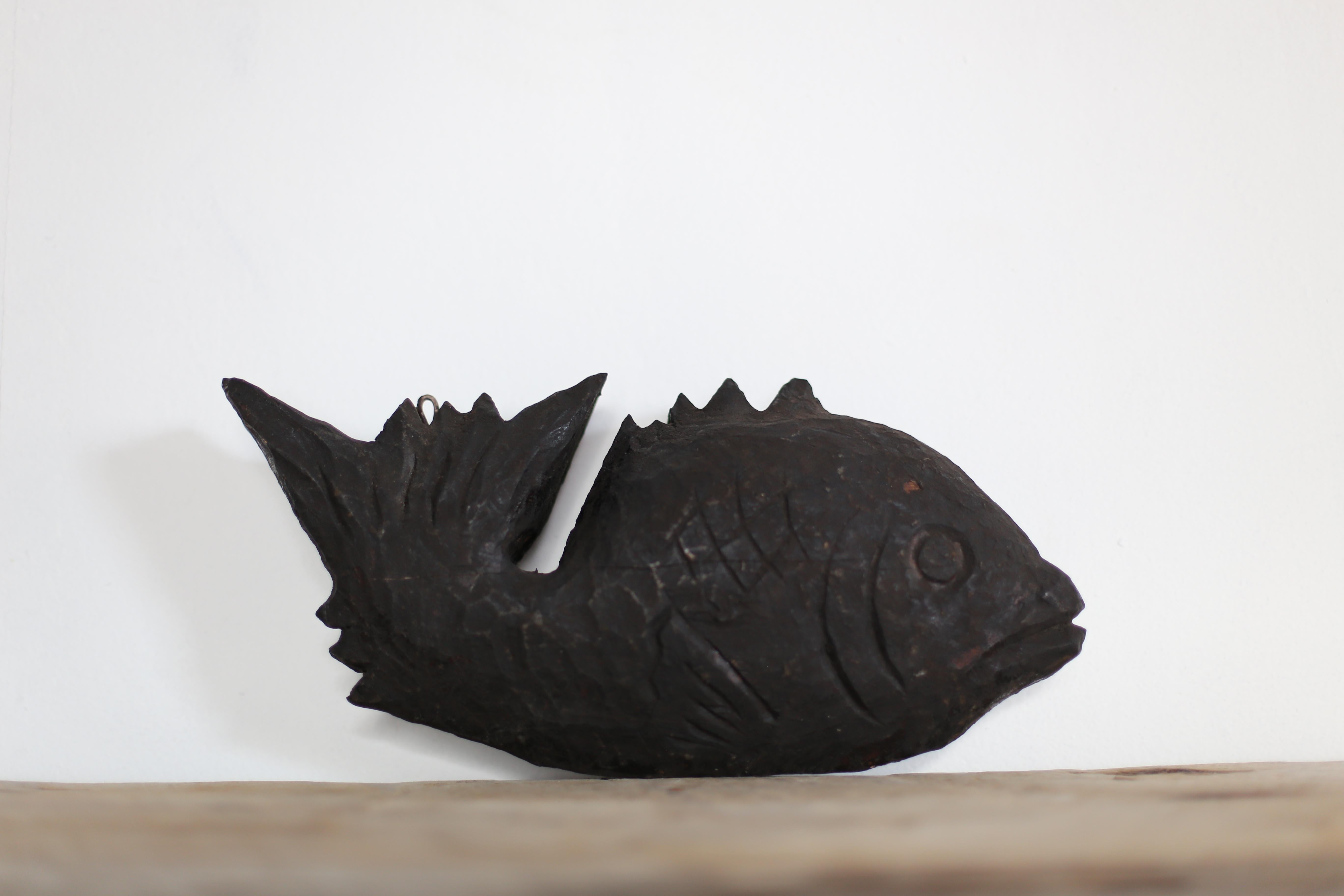 This is a very old Japanese wood carving of a fish.
It is a wood carving from the Meiji period (1860s-1900s).
It is carved from cedar wood.

This wood carving is attached to a free hook used in hearths.
Fish are considered lucky charms, as they