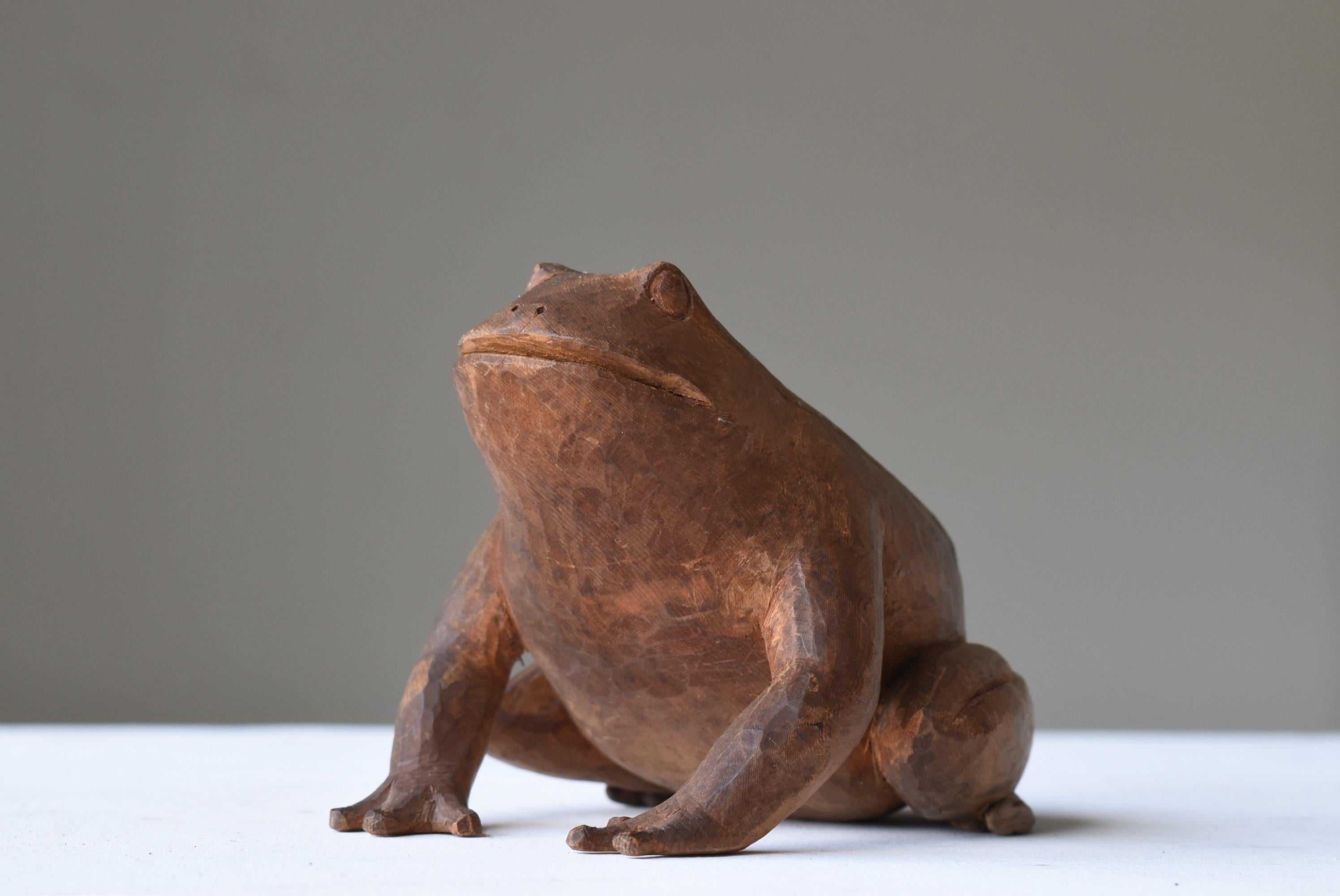This is an old Japanese wood carving of a frog.
This item is from the Meiji era. (1860s to 1920s).
It is made of cedar wood.

In Japan, frogs are considered to be good luck charms.
This one seems to have been worshipped as a guardian