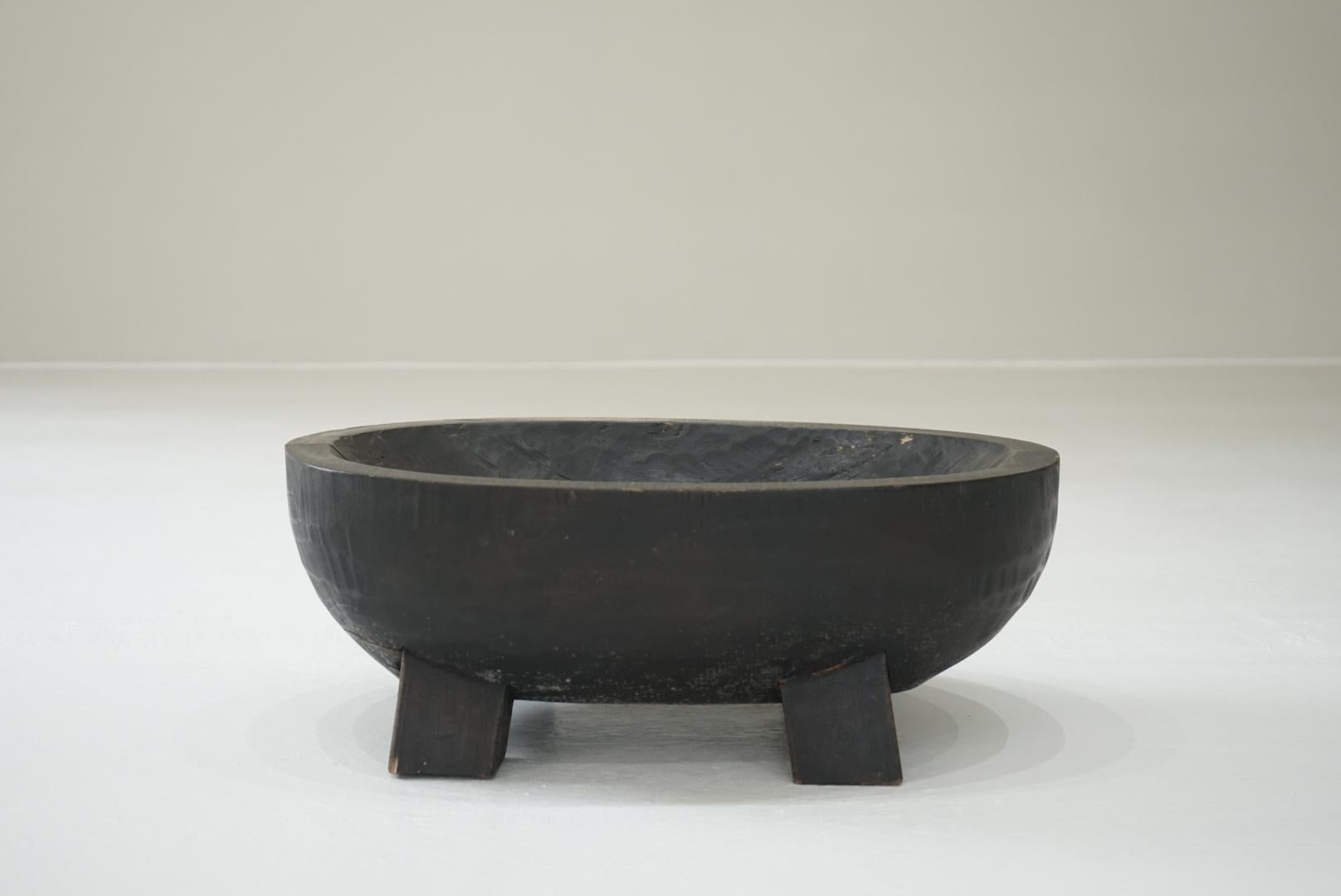 This is an old Japanese wooden bowl with legs.
The wooden bowl is dyed black.

It is likely that this was made as a manger.
However, there is no evidence that it was ever used, so I think it is dead stock.

The inside of the bowl shows signs of