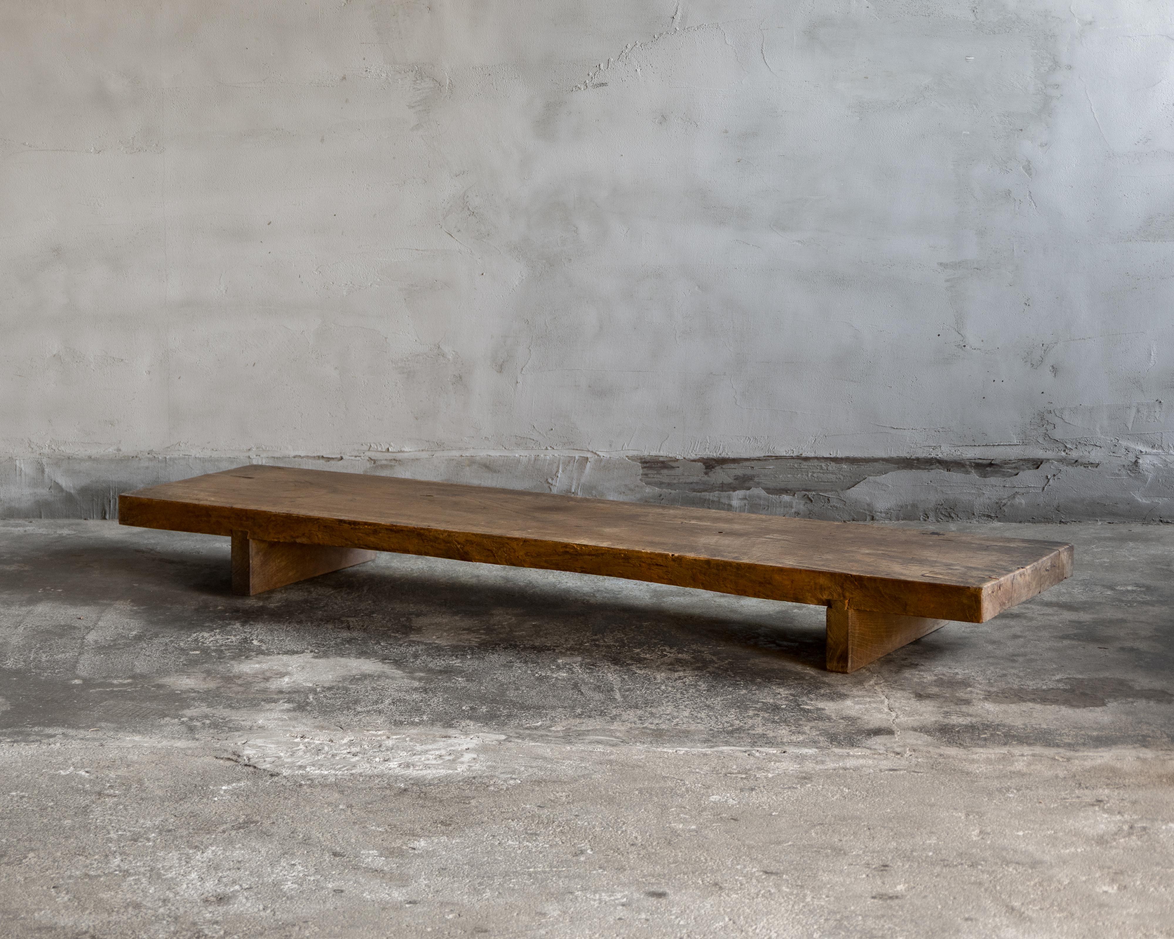 Cette table basse japonaise ancienne en bois (tachidai) a été fabriquée à la fin de la période Meiji (1890-1912).

Entièrement réalisée en keyaki (zelkova japonais), la dalle unique conserve un live edge (bord naturel), préservant le contour