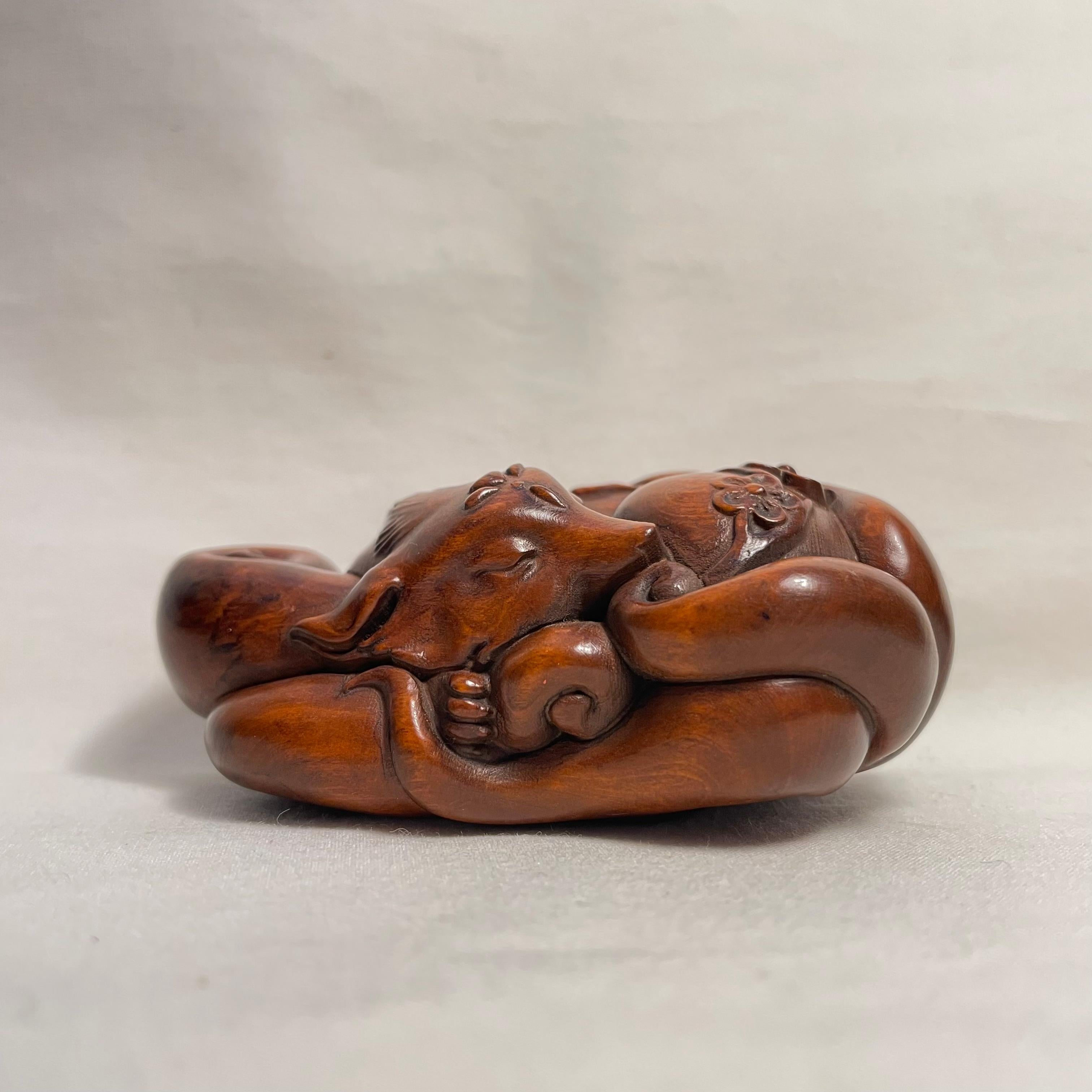 This is an antique wooden netsuke made in Japan around Taisho period 1920s.

Netsuke is a miniature sculpture, originating in 17th century Japan.
Initially a simply-carved button fastener on the cords of an inro box, netsuke later developed into