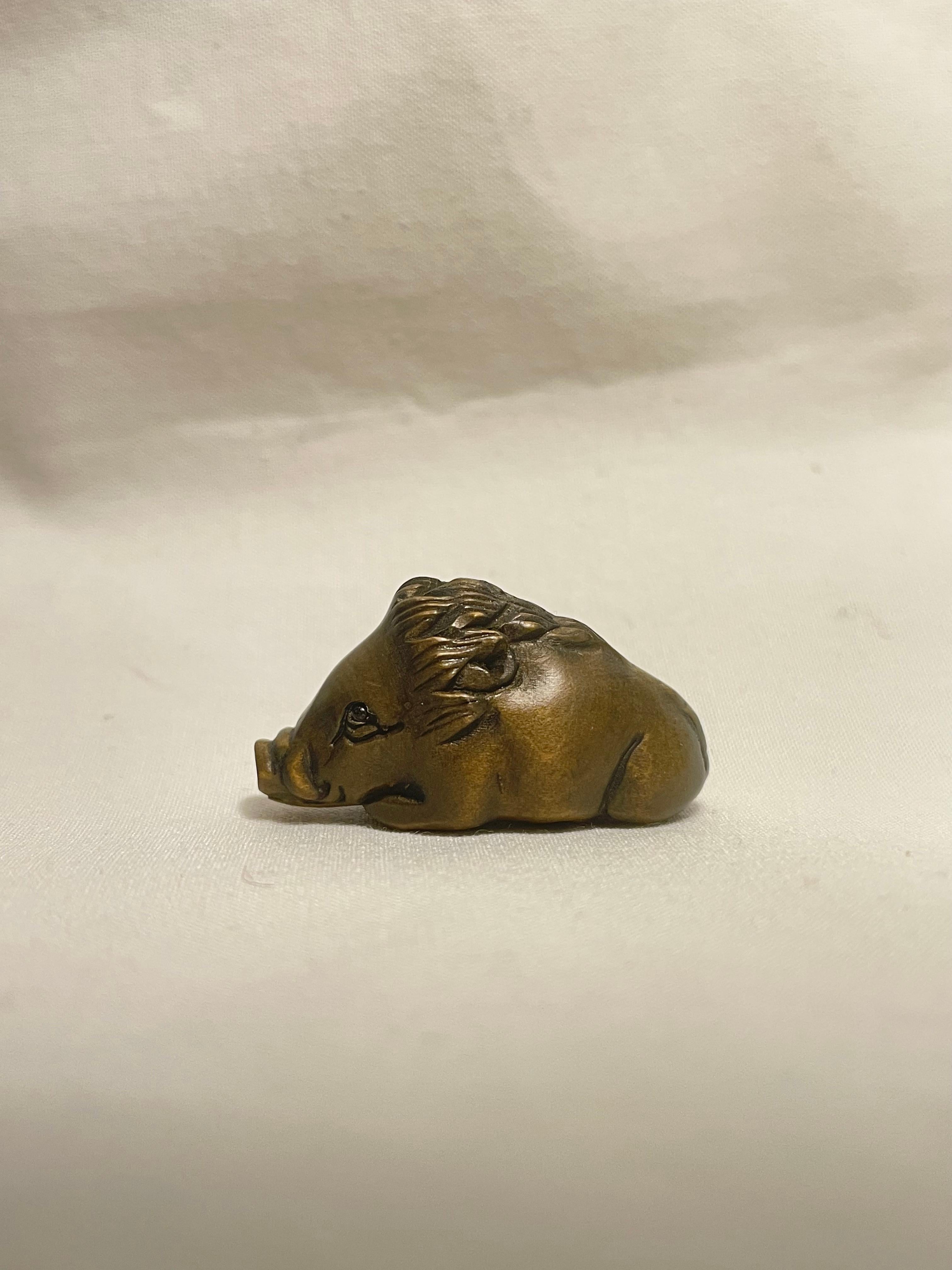 This is an antique netsuke made in Japan around Showa period 1960s.

Dimensions: 3.5 x 1.5 x H2 cm
Sculpture: Wild Boar
Era: 1960s (Showa) 

Netsuke is a miniature sculpture, originating in 17th century Japan.
Initially a simply-carved button