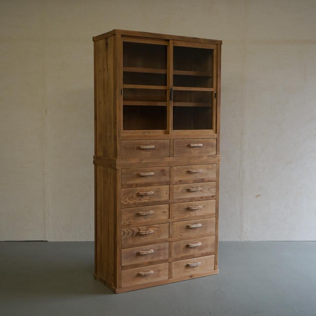 This is an old Japanese glass cabinet.
The frame is all made of solid cedar wood.
It has 14 drawers, and it looks like a picture just by storing it there, but it is also a practical storage shelf that can store things you want to show and things you