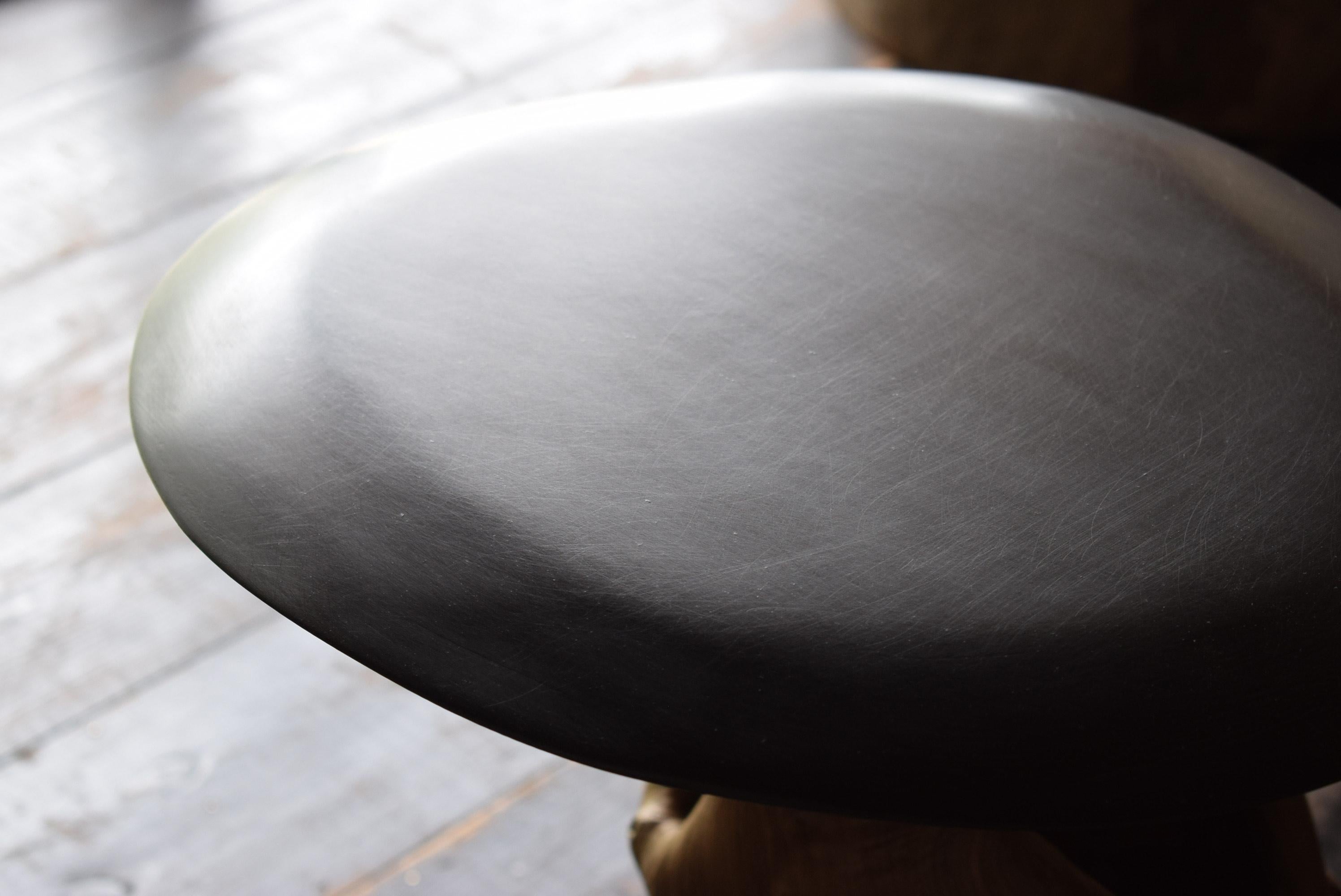 This table is made by combining an old tree stump with a newly carved tabletop. The tabletop is made using cashew paint, which gives it a lacquer-like finish, and has a jet black finish with fine hairlines, giving it a surface that looks like black