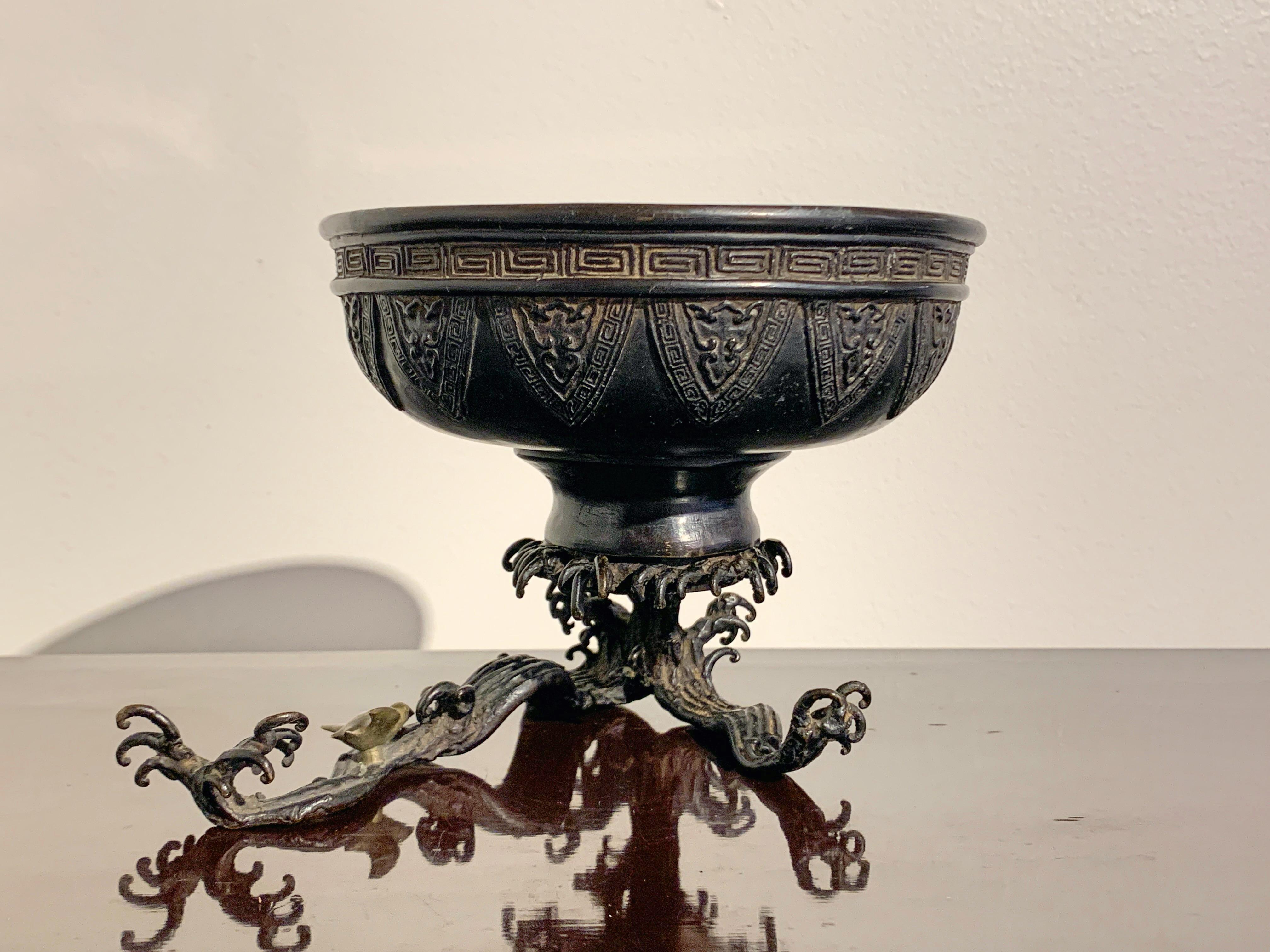 A finely cast Japanese bronze usabata, designed as an archaistic bowl being supported by crashing waves, Meiji period, late 19th century, Japan.

The usabata is an essential component for certain schools of ikebana, or Japanese flower arranging.