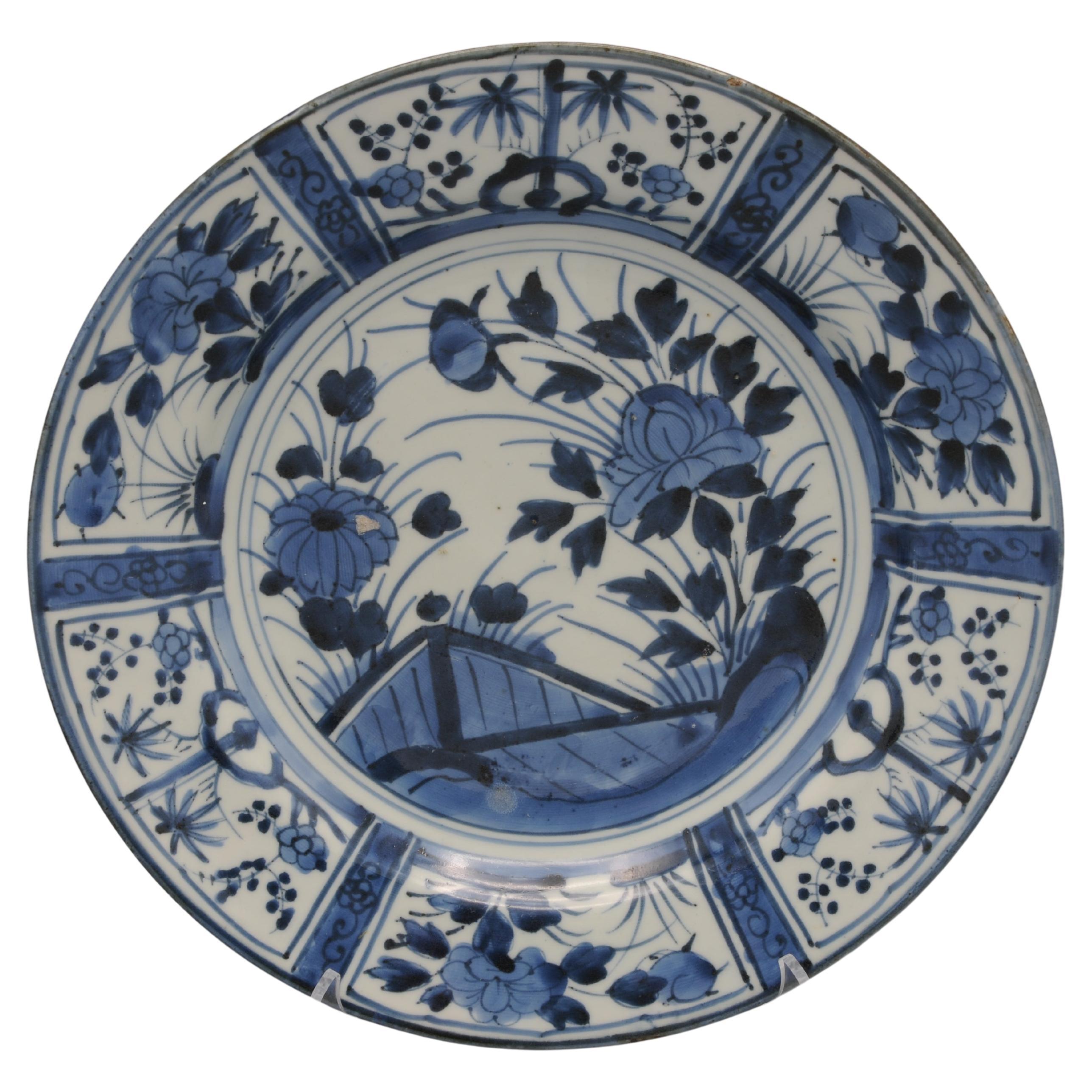A 17th Century Japanese Blue and White Porcelain Dish in the Kraak Style, Arita Kilns 1670 – 16800. 
Decorated in underglaze blue with flowering chrysanthemums growing from behind a fence and flowering peonies growing from pierced rockwork enclosed