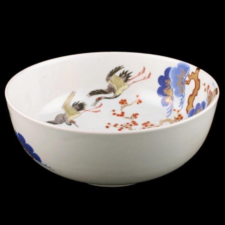 A late 19th century Meiji period (1868-1911) Japanese Arita porcelain bowl.

The bowl has a white background with hand painted decoration of trees, flowers, foliage and the interior has cranes and their young.

The bowl has a raised foot with a