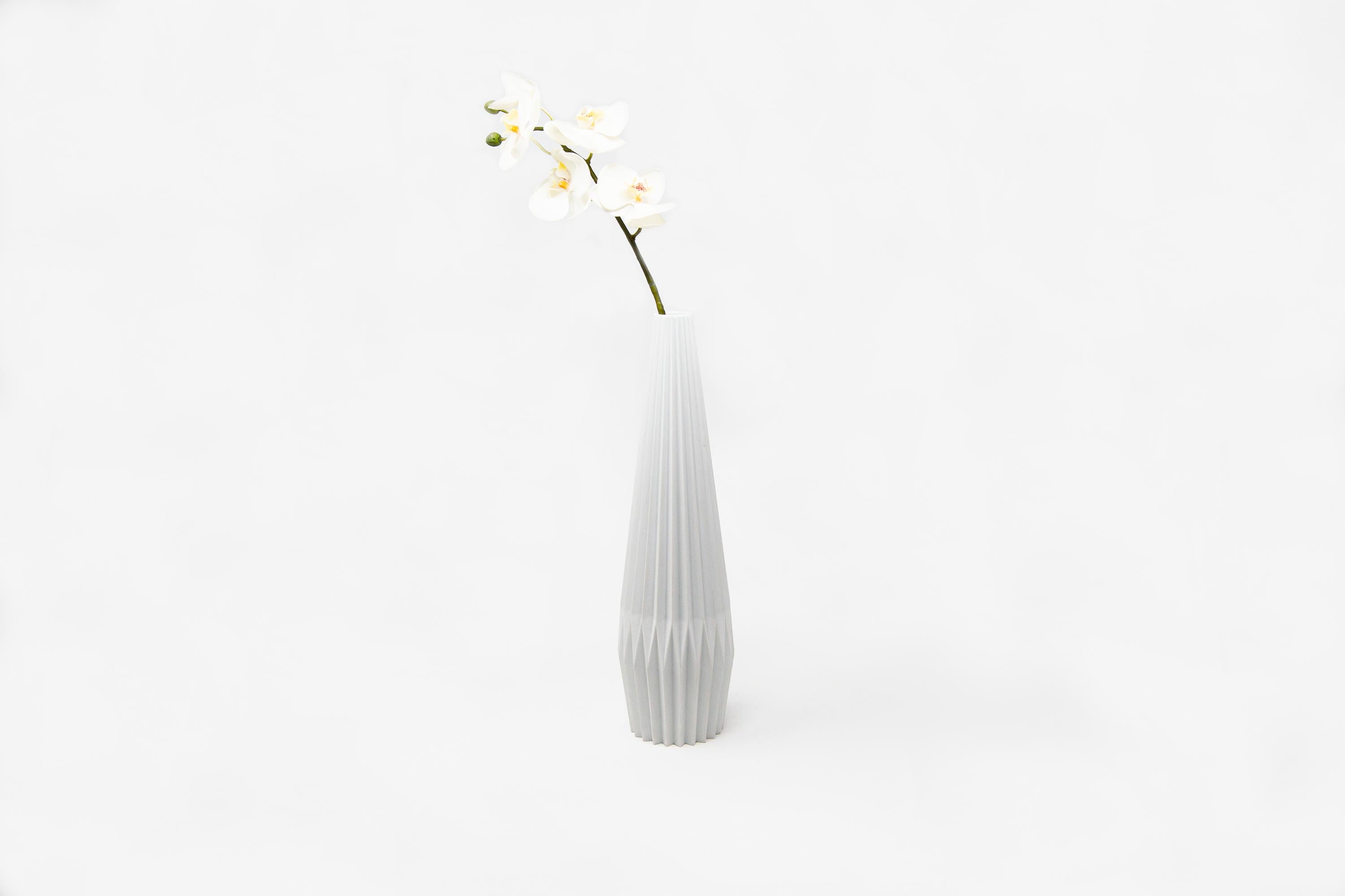 This vase is designed by Denis Guidone and handmade in Japan by Risogama for Hands on Design, a traditional pottery. It reminds the Japanese tradition of Origami, the designer uses the white Arita porcelain like paper and lighten the appearance of