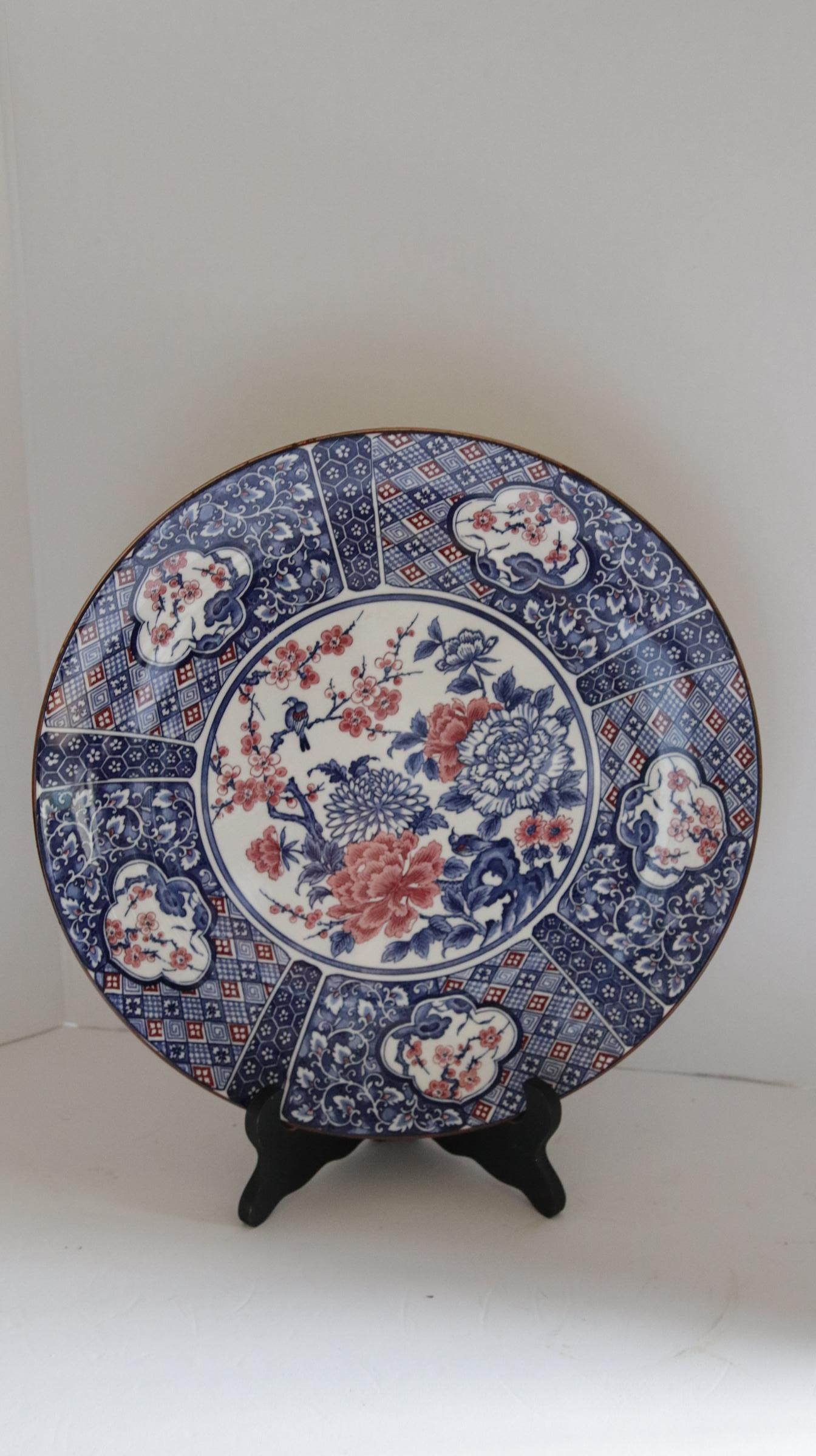 This is a beautiful Arita charger that has the most appealing color palette in salmon, blue and white. It is 13 inches wide and deep. It has a fluted rather than flat shape. The underglaze reflects lots of light that gives the charger a high-glaze