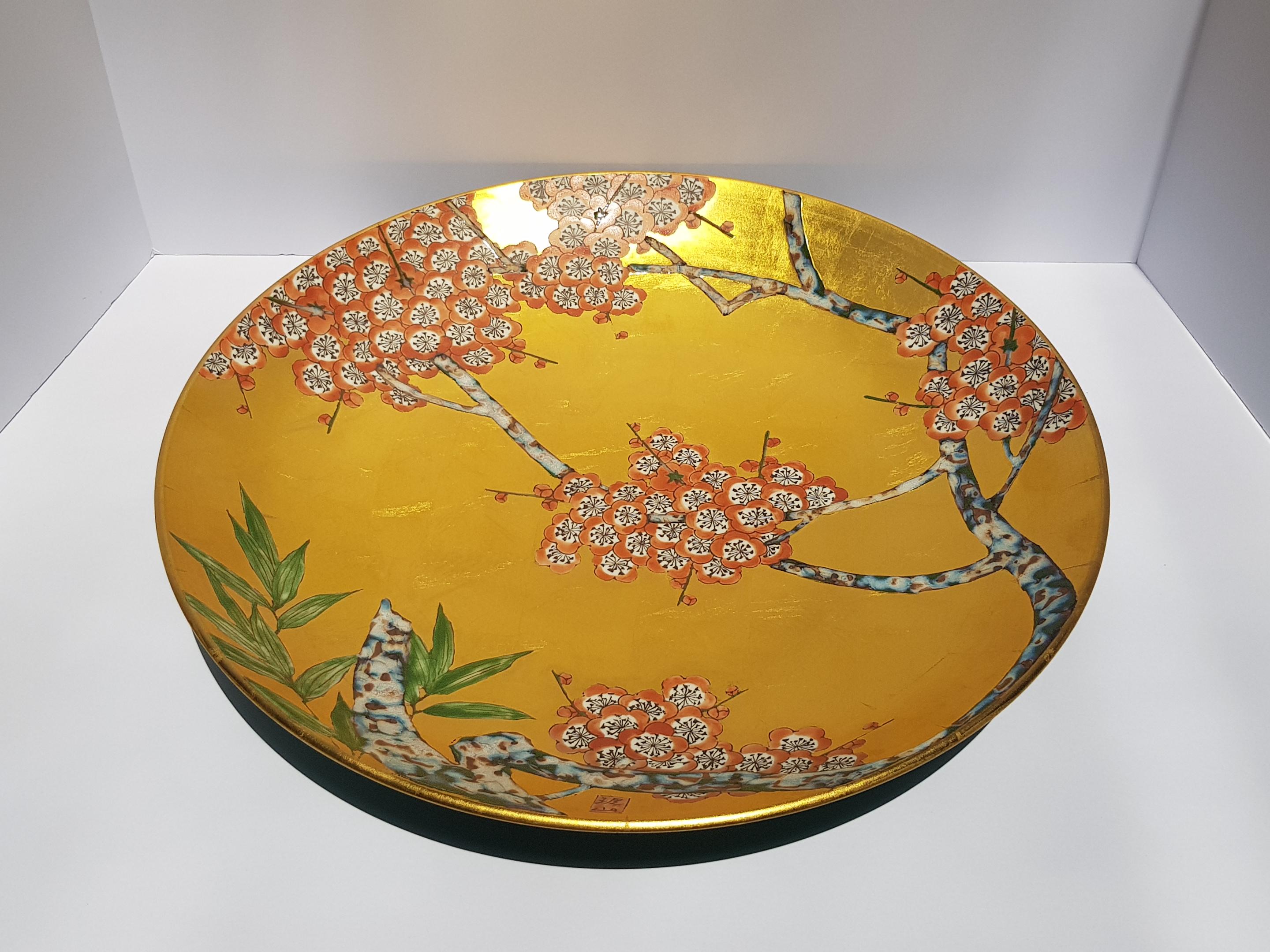 An exquisite and rare Japanese Arita Ware large porcelain ceramic decorative plate or charger hand crafted by skilled Japanese artisans. Entirely handmade this Arita Ware plate feature rich 24 karat gold leaf throughout and is adorned with delicate