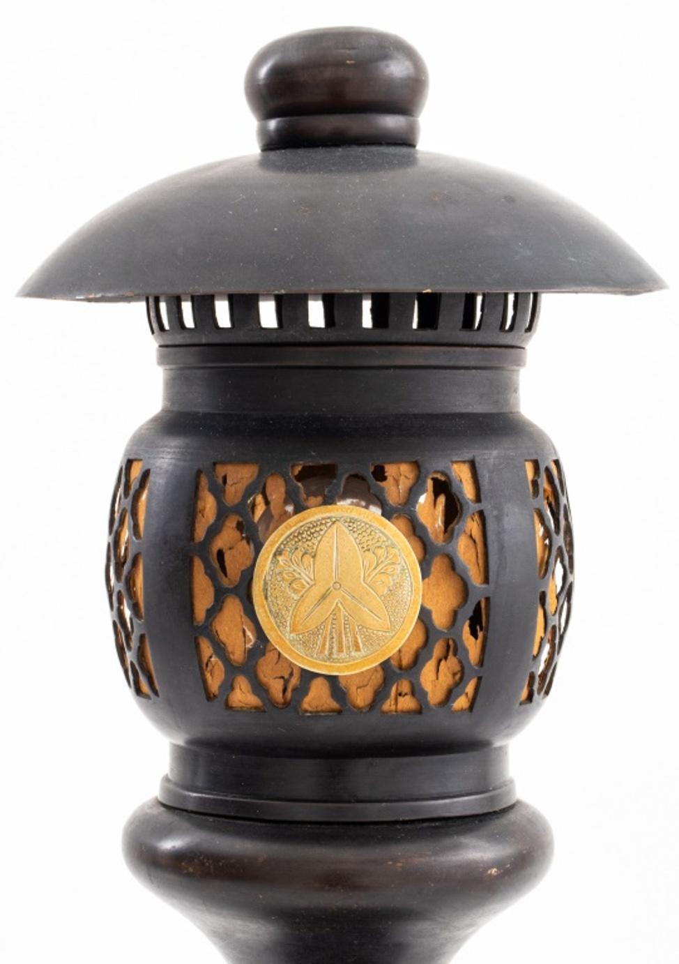Japanese Art Deco gilded brass mounted bronze lamp in the form of a Toro Lantern with domed cover and silk-lined reticulated globe mounted with a Kamon crest above a turned base mounted on a gilt brass plinth.

Dealer: S138XX