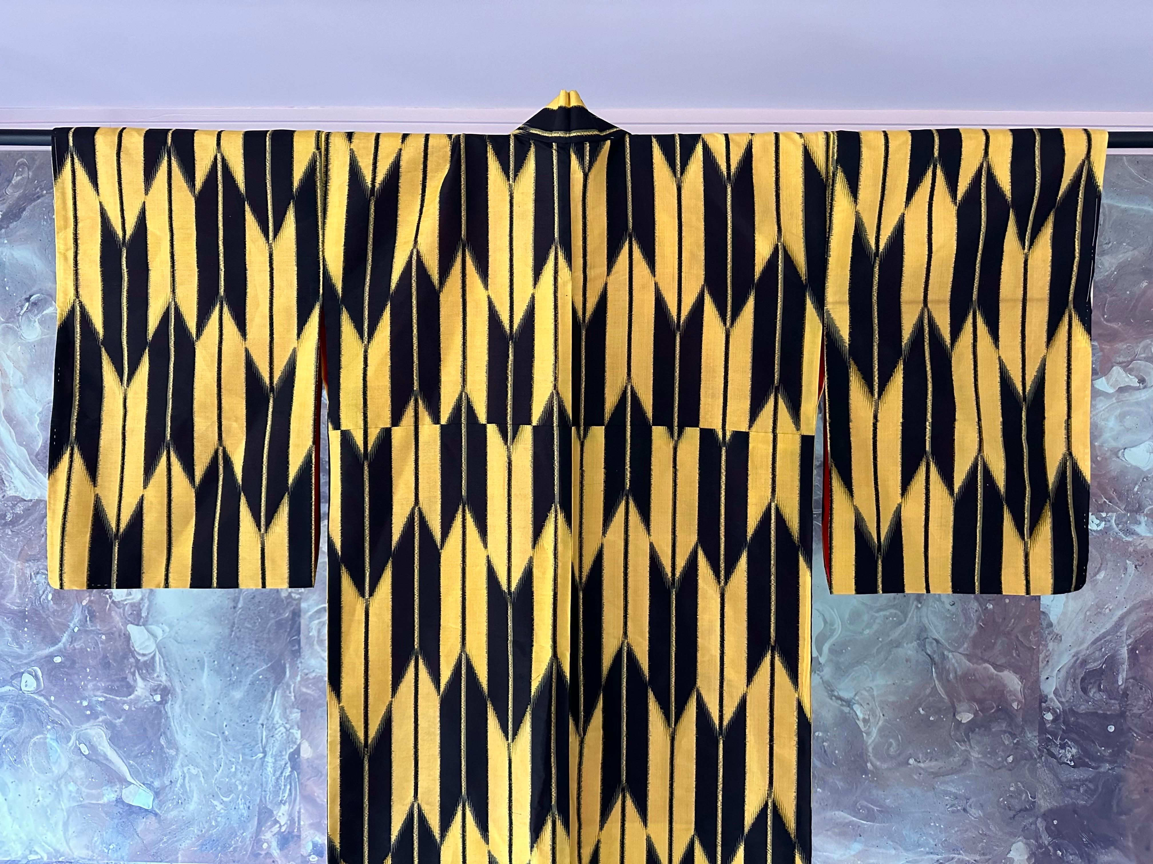 A well preserved Japanese Meisen kimono hand-sewn from woven Ikat Silk circa 1920-30s (Taisho to early Showa period). The kosode style kimono (small sleeve), tailored from raw silk with bold geometrical pattern of arrowheads and lines in contrasting