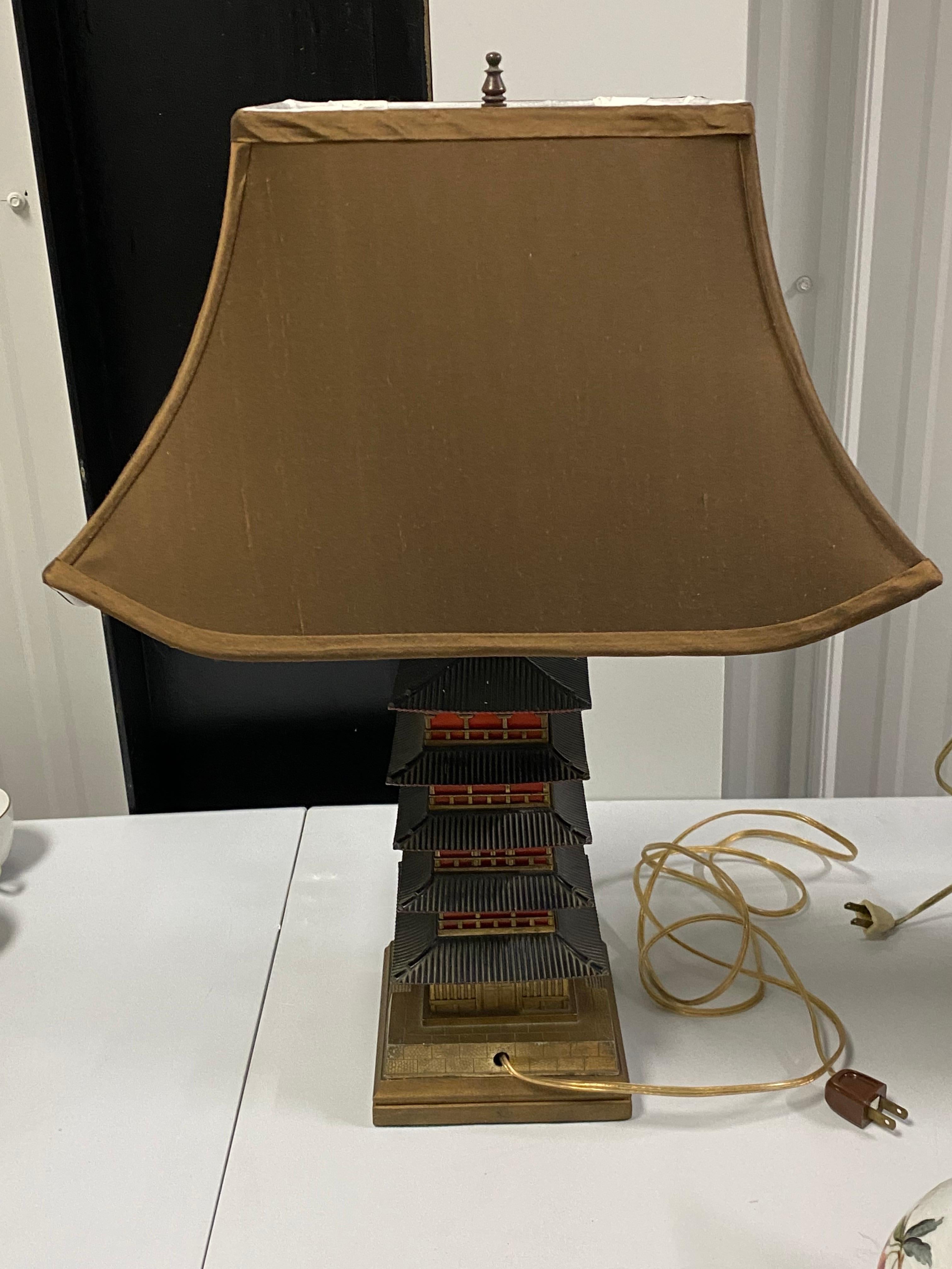 Japanese Style Art Deco Pagoda Lamp, 20th Century
A bronze & brass Japanese Style Pagoda Lamp, 20th Century. Knob on base moves to the right to illuminate. Column illuminates to a brilliant red color.  Interesting architectural pagoda. Good working