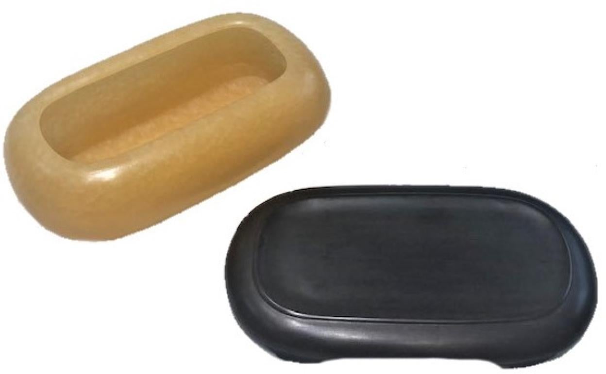 An elegant vessel of a very unusual rectangular streamlined shape is hand carved from a natural yellowish stone, fitted into a handcrafted noble wood gift box with the interior upholstered in dark green silk, circa 1930.

Dimensions of
