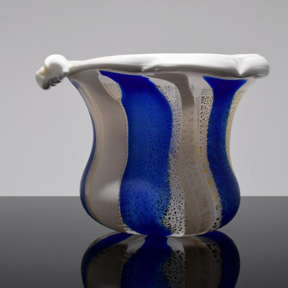 Eine freistehende Glasskulptur in Form eines offenen Gefäßes von Kyohei Fujita (1921-2004). Das auffällige Stück hat einen organischen Körper mit abwechselnd blauen, weißen und transparenten Streifen mit goldenen Glitzereinlagen. Der Rand nimmt eine