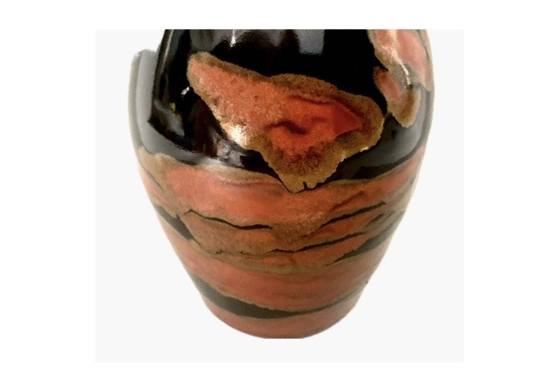 A well made and understated UlGlazed pottery vase having baluster form in a dark glaze and accentuated with relief brown, rust and golden/coppery elements. The vase is artist signed in relief on verso. Smooth semi-gloss patina.

Dimensions: 5 1/2