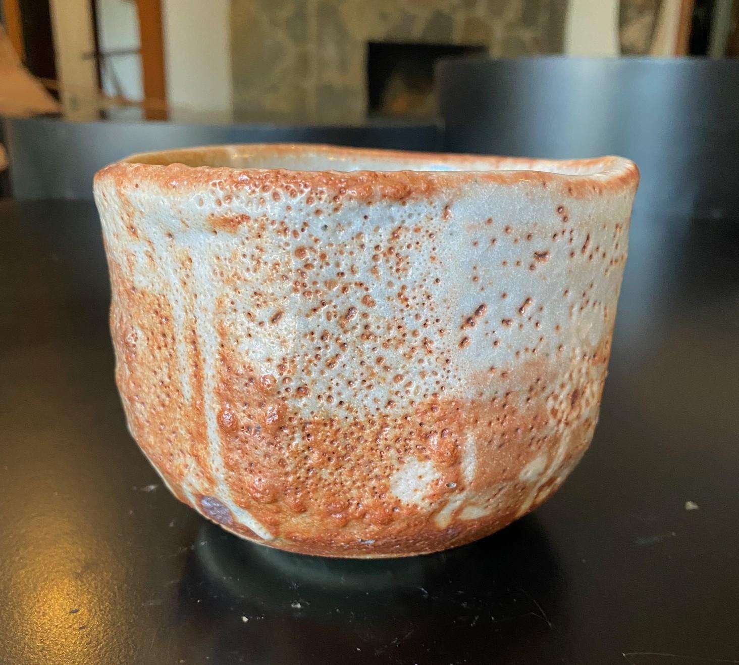 Eine schöne japanische Mingei Nezumi Shino Ware (志野焼, Shino-Yaki) Keramik Chawan Teeschale für Teezeremonie, die eine prächtige Glasur mit wunderbaren subtilen Verschiebungen in Farbe, Muster und Textur und ein dekoratives Blumenmotiv entlang einer