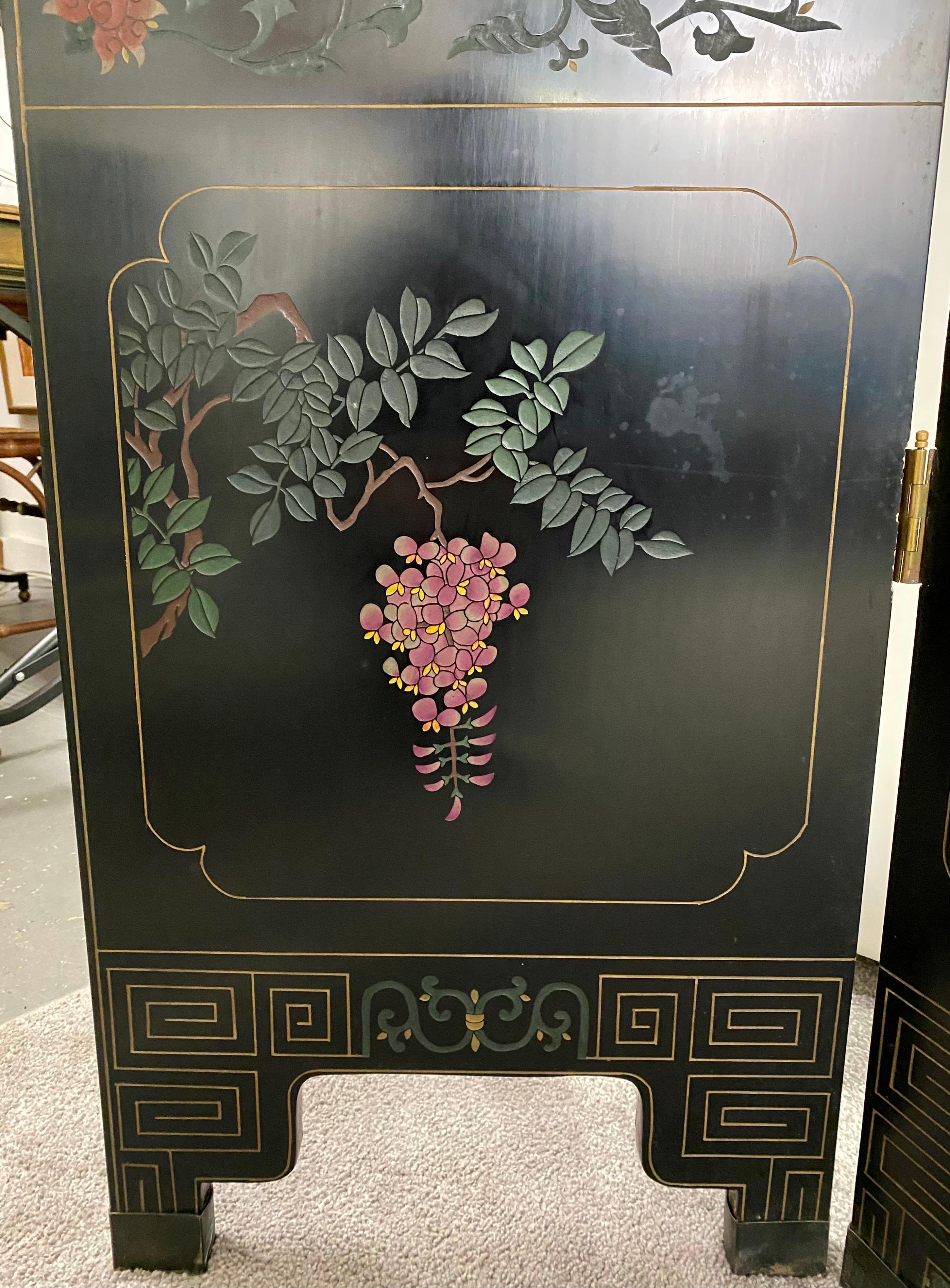An exquisite wood 4 panel lacquered Asian Japanese room divider or screen in ebony. One side of the screen portrays carved design of imperial ladies dancing and dressed in colorful outfits as well as floral patterns framing the panels. The back of