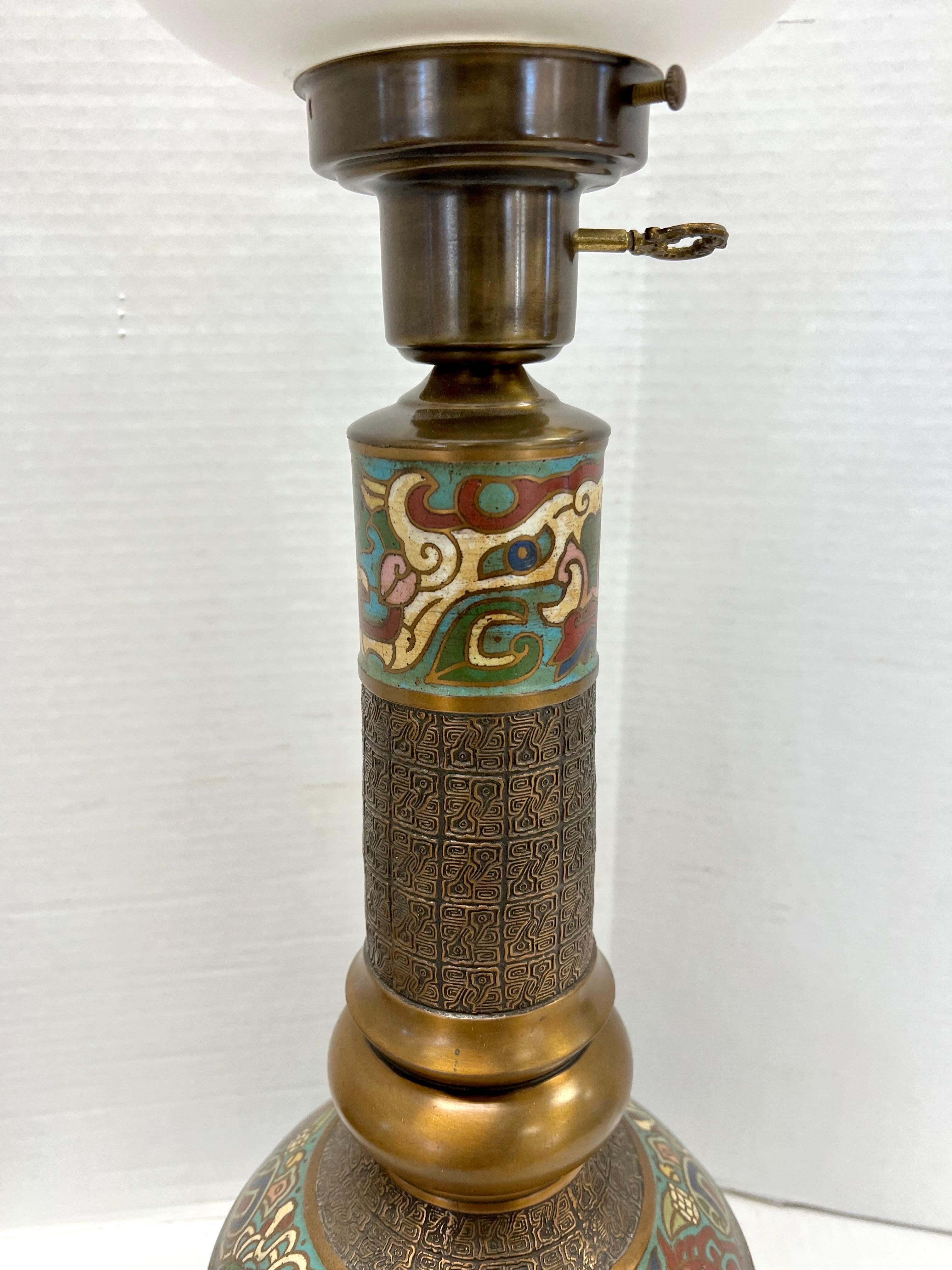 Stunning Japanese brass champleve table lamp with colorful enamel detail topped with an etched glass hurricane lamp. Why not own the best? Wired for USA and in working order.