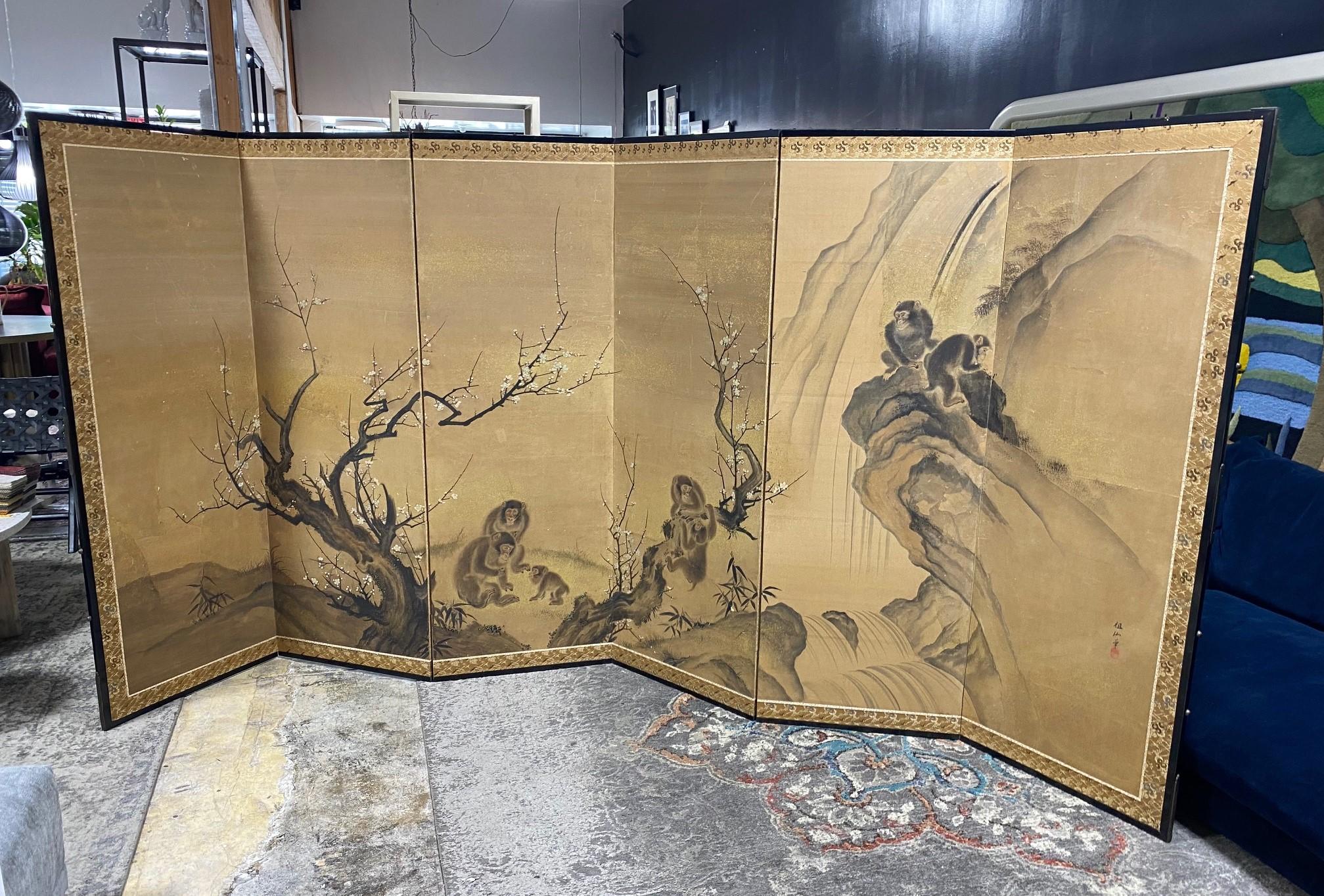 An absolutely gorgeous, wonderfully composed six-panel Japanese Byobu folding screen/room divider depicting a family of playful monkeys among the blooming trees and mountainous landscape. The beautiful hand painted detail really makes this an