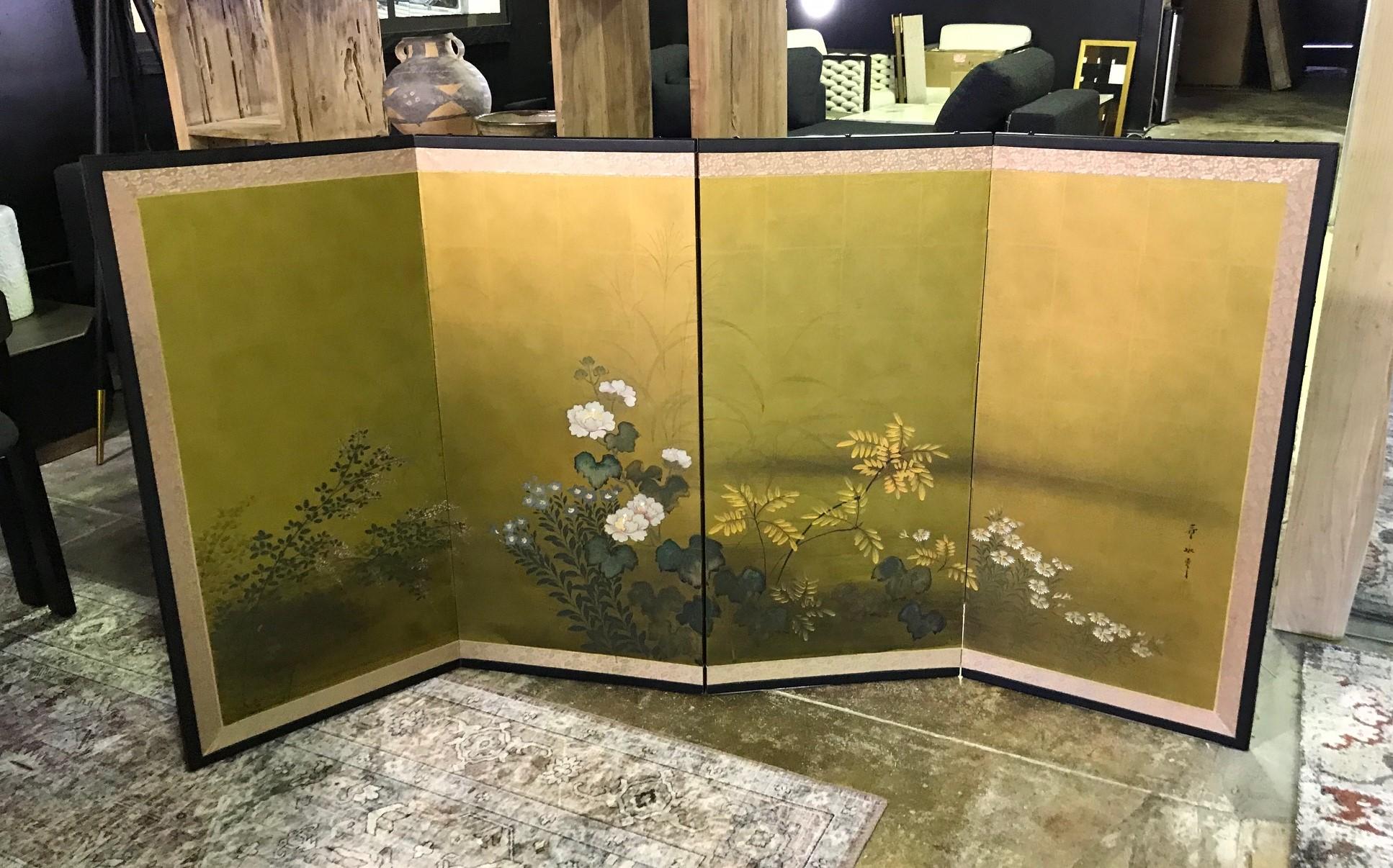 A gorgeous and delicately detailed hand painted four-panel Japanese Byobu folding screen depicting a nature scene with various blossoming flowers. The rich colors, gold leaf, and beautiful hand painted fine detail of the floral population really