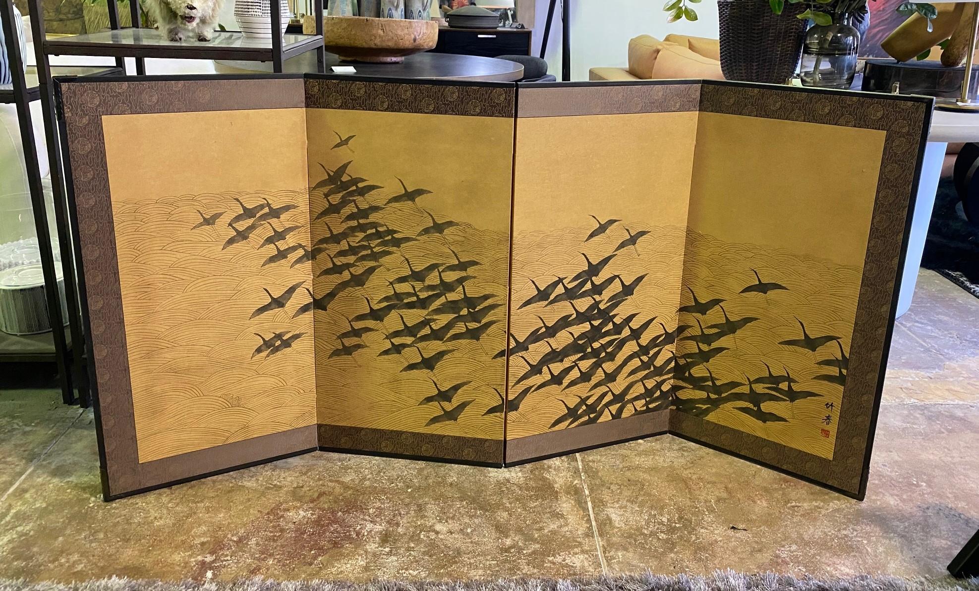 A gorgeous four-panel Japanese Byobu folding screen depicting a flock of silhouetted cranes/birds in flight over a vast oceanic landscape. The screen is subtly and beautifully hand-painted. It is quite an attractive work like no other we have