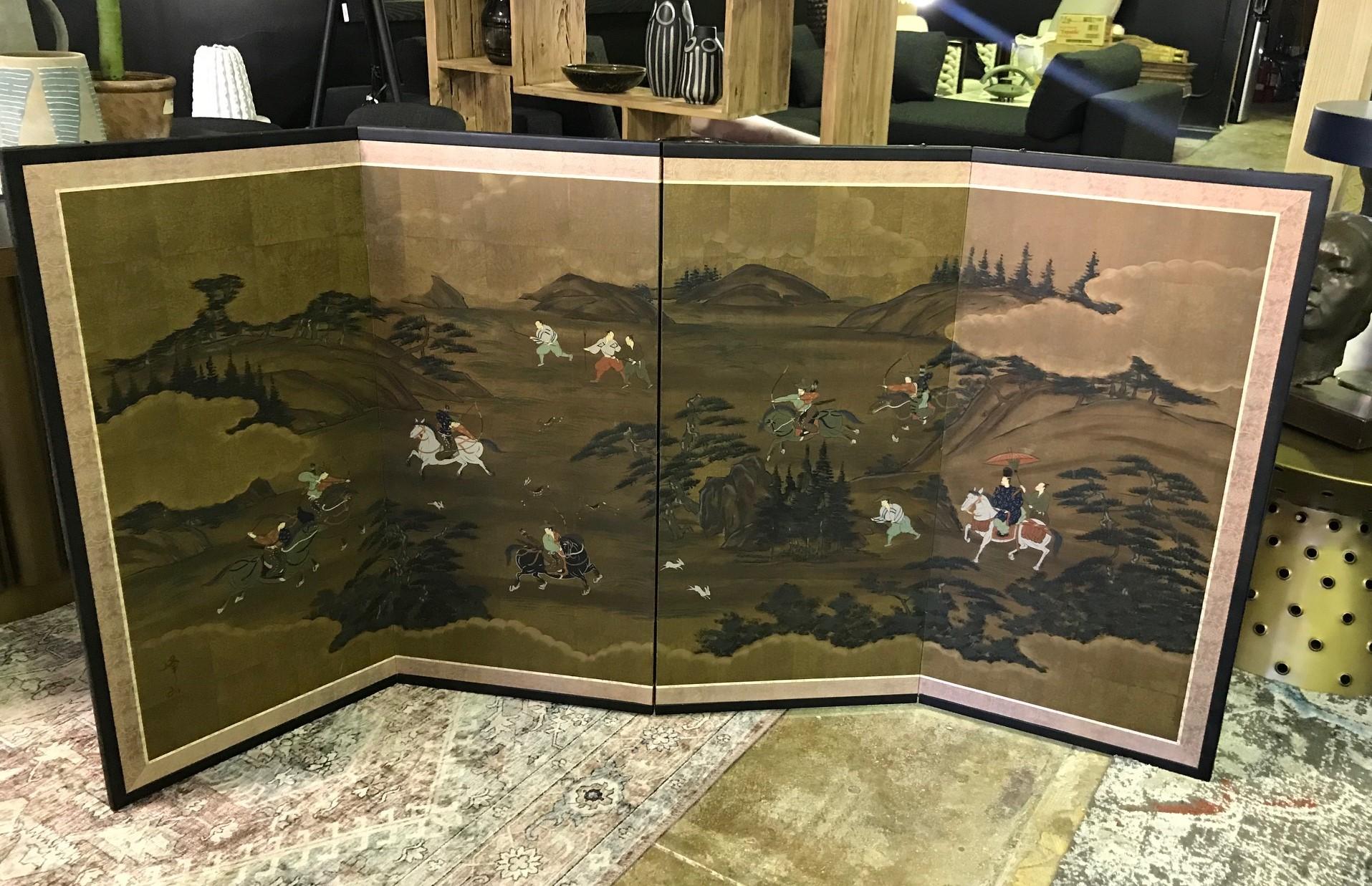 A gorgeous four-panel Japanese Byobu folding screen depicting a hunting scene with various warriors and animals spread across a vast mountainous landscape. The dark rich colors, deep gold leaf, and beautiful hand painted detail really make this an