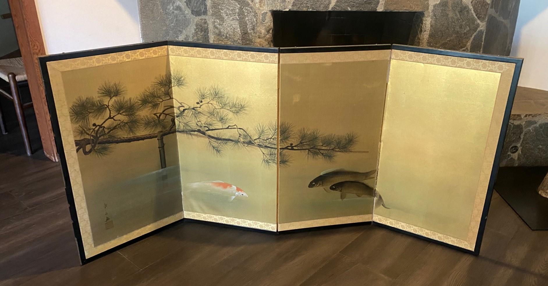 Uno splendido paravento pieghevole Byobu giapponese del periodo Showa a quattro pannelli con tre luminosi pesci Koi/Carpa che nuotano e il ramo teso di un pino Vener che si appoggia serenamente su un tranquillo corso d'acqua. I colori vivaci e