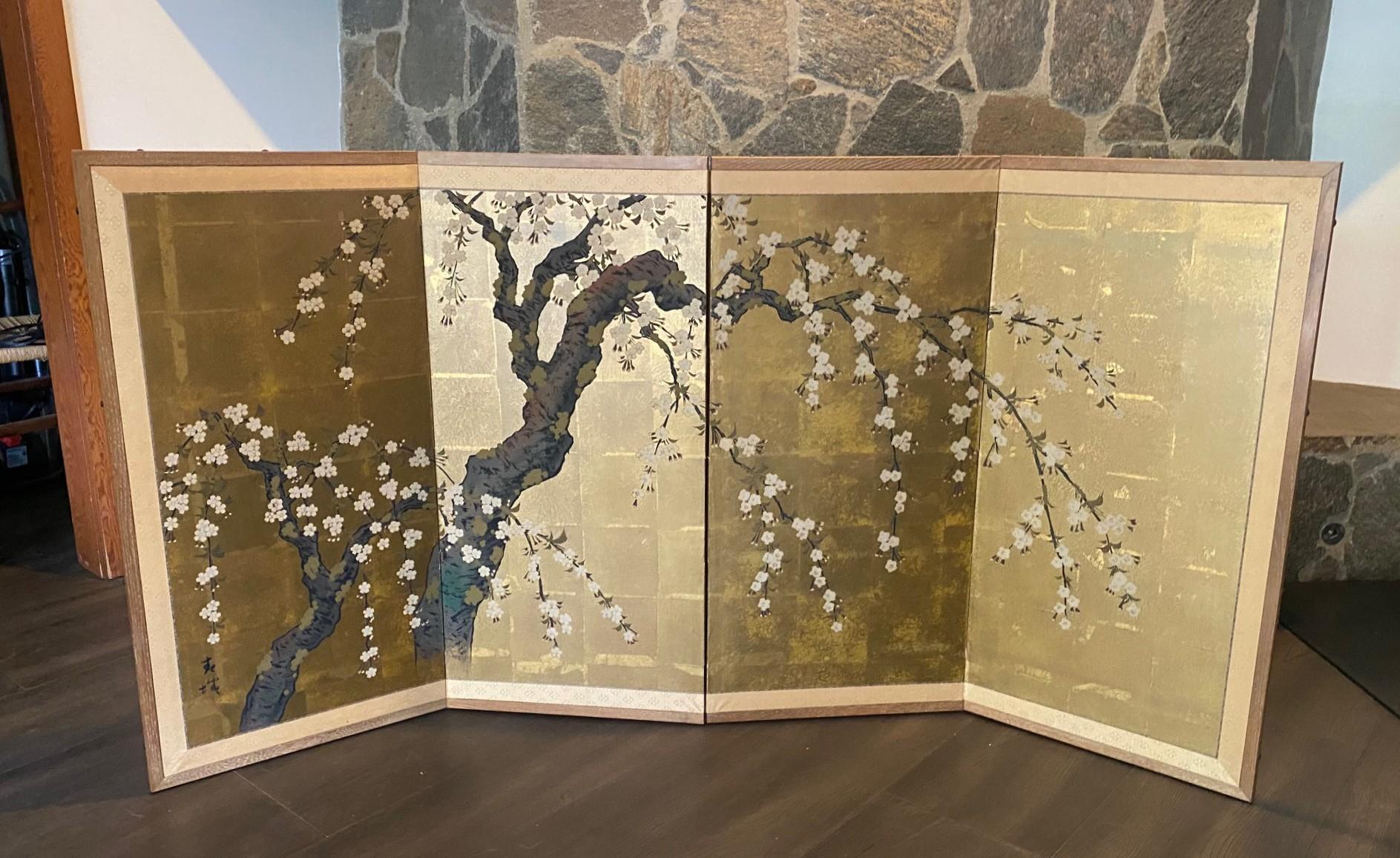 A gorgeous four-panel Japanese Byobu folding screen depicting a cherry blossom tree in full bloom.. The vibrant, rich colors, gold leaf, and beautiful hand-painted detail of the tree branches and cherry blossom flowers make this quite an attractive