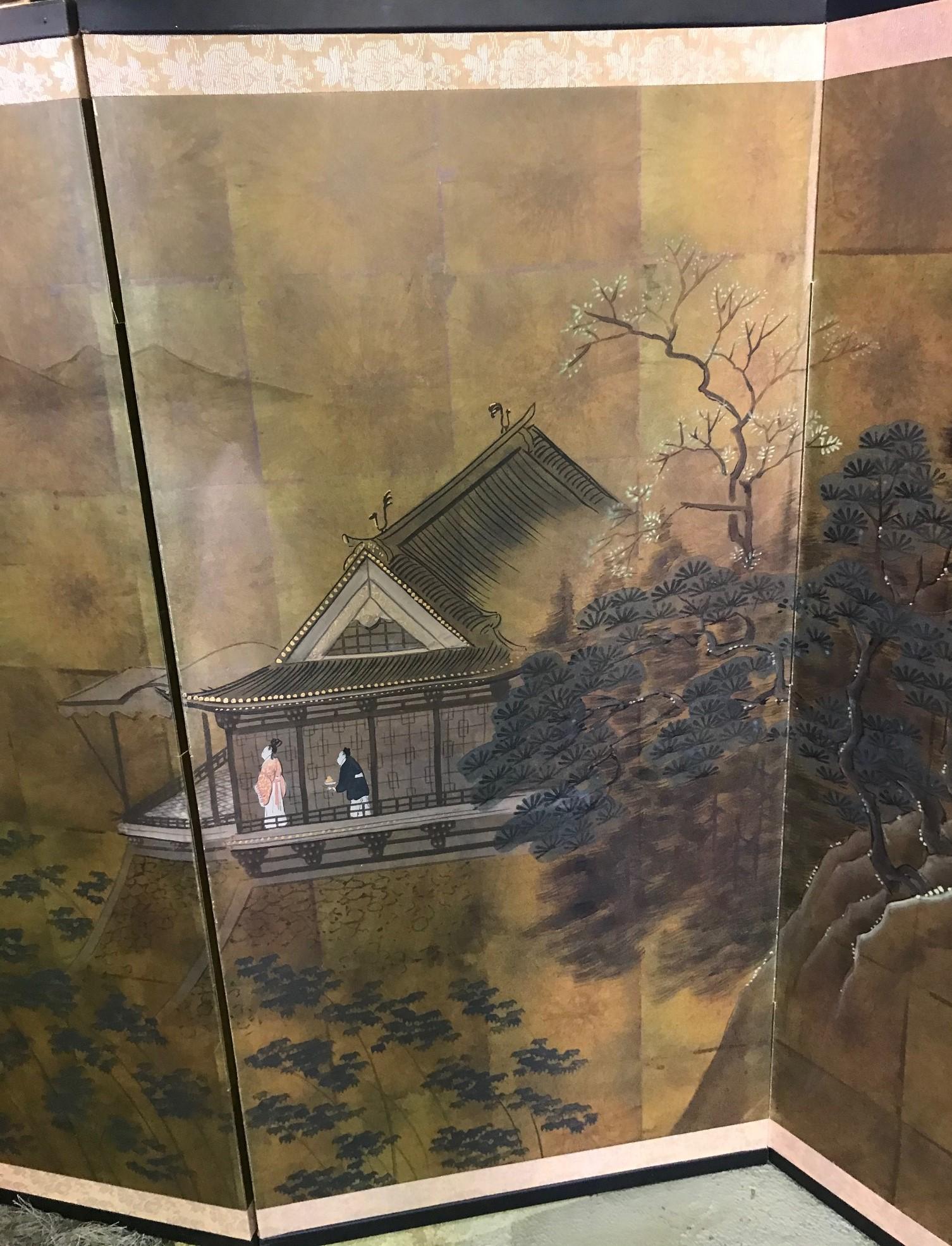 A gorgeous four-panel Japanese Byobu folding screen depicting a couple on the balcony of their Hillside home overlooking boaters on a lake and vast countryside landscape. The dark rich colors, deep gold leaf and beautiful hand painted detail really