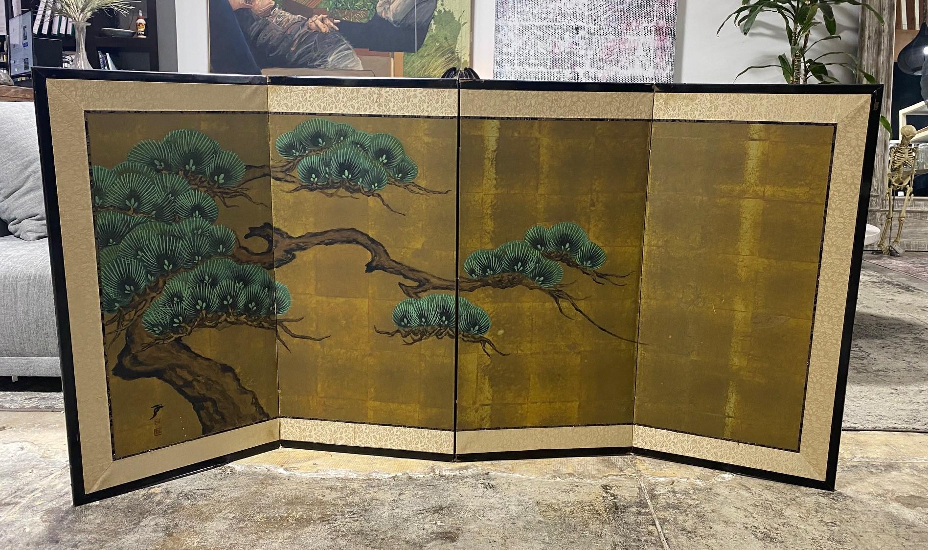 A gorgeous hand-painted four-panel Japanese Byobu folding screen depicting a blossoming venerable pine tree with limbs stretching out over a bluff. The deep, rich colors, gold leaf, complex design/composition, and beautiful hand-painted detail of