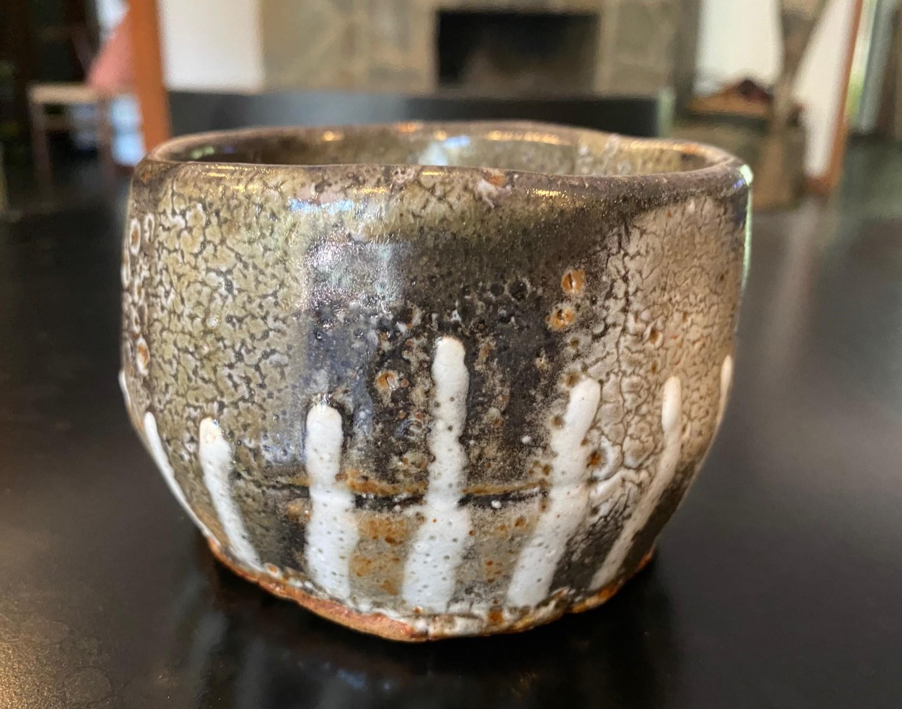 Un magnifique bol à thé chawan en poterie japonaise de studio qui présente un mélange de couleurs, de glaçures et de textures changeantes ainsi que des éléments de Shino Ware et de Hagi Ware.  La pièce rayonne dans la lumière.  

Cette pièce