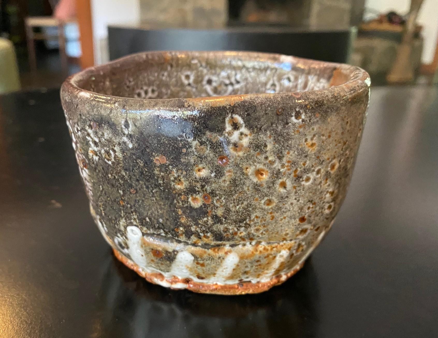 Un magnifique bol à thé chawan en poterie japonaise de studio qui présente un mélange de couleurs, de glaçures et de textures changeantes ainsi que des éléments de Shino Ware et de Hagi Ware.  La pièce rayonne dans la lumière.  

Cette pièce