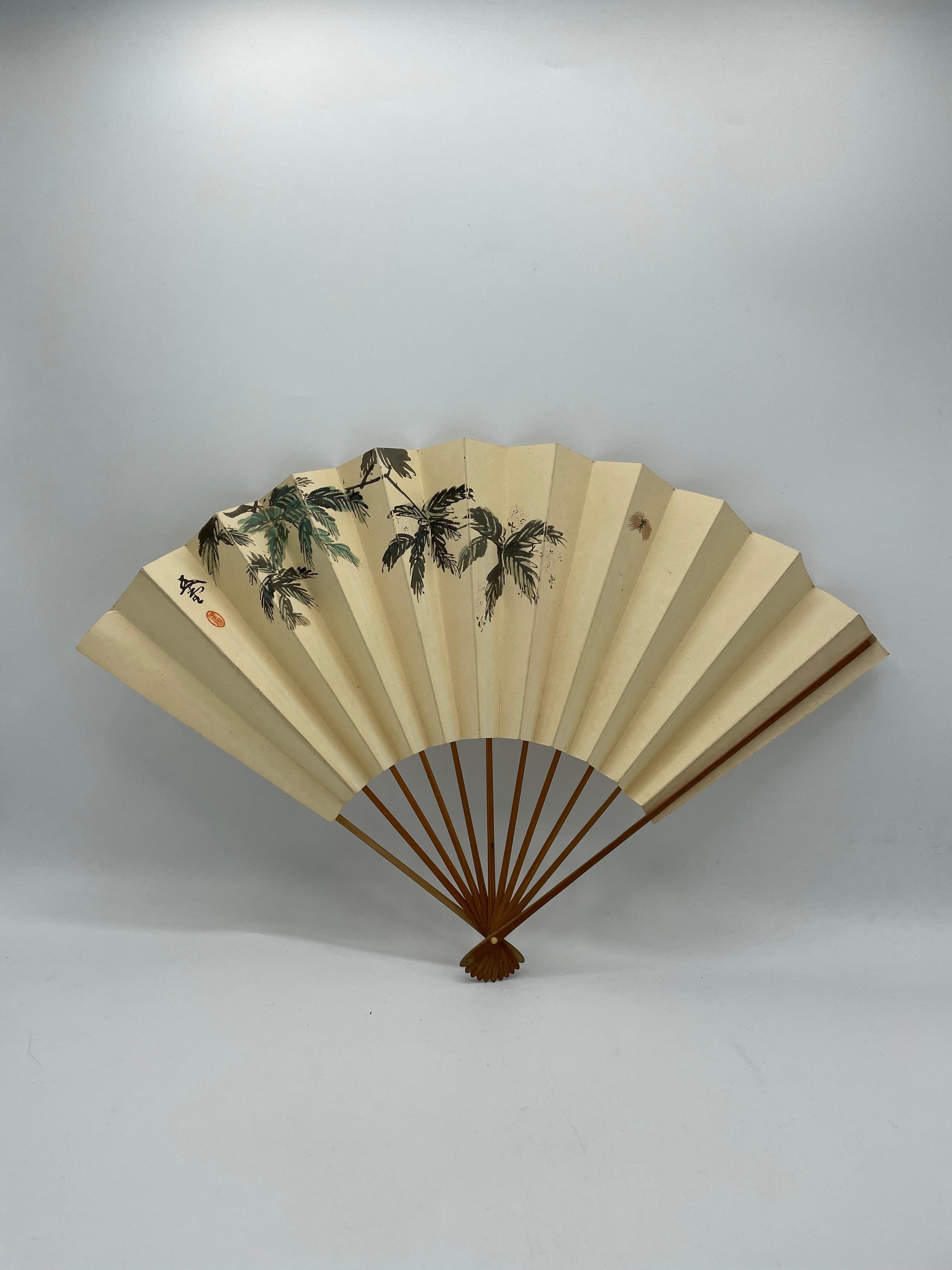 This is a fan which was made in Japan around 1980s in Showa era.
This is made with a paper and bamboos. This fan is printed.

Japanese fans are made of paper on a bamboo frame, usually with a design painted on them. In addition to folding fans