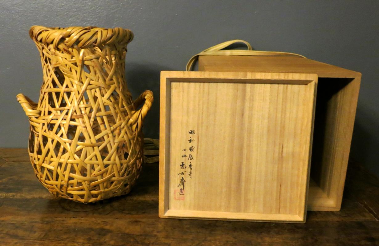 Un delizioso cesto di bambù giapponese realizzato da Hayakawa Shokosai IV, la quarta generazione della stirpe Shokosai, una delle più note nell'arte del bambù giapponese. Il cesto è stato realizzato a treccia irregolare utilizzando il bambù Phoenix