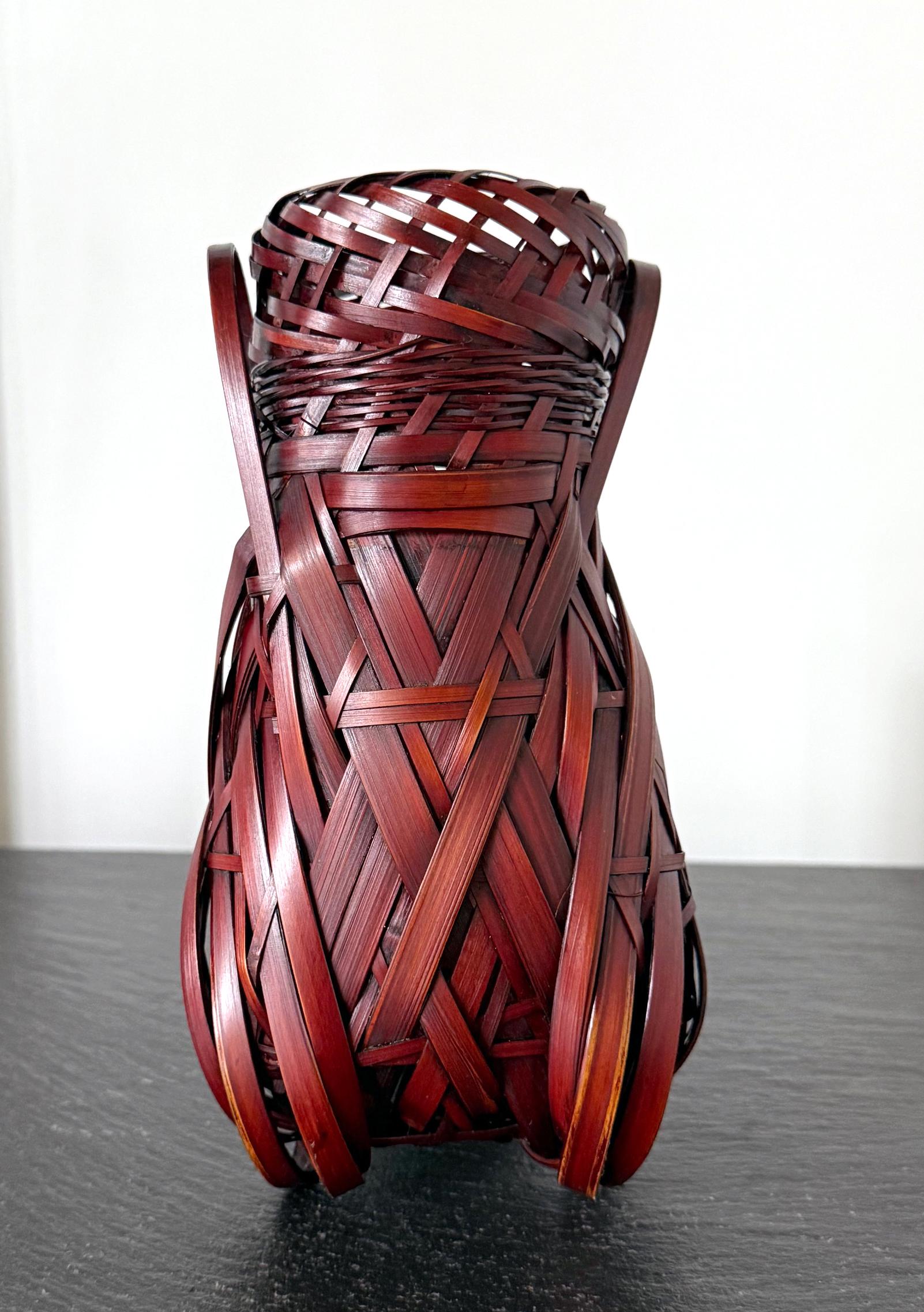 Ce petit panier ikebana (Hanakago) a été tressé à la main par l'artiste japonais Yufu Shohaku (1941-) dans les années 2000. Le panier a été tressé en forme de Cicada, un insecte qui, au Japon, est associé à l'été. La jolie forme a été obtenue par un