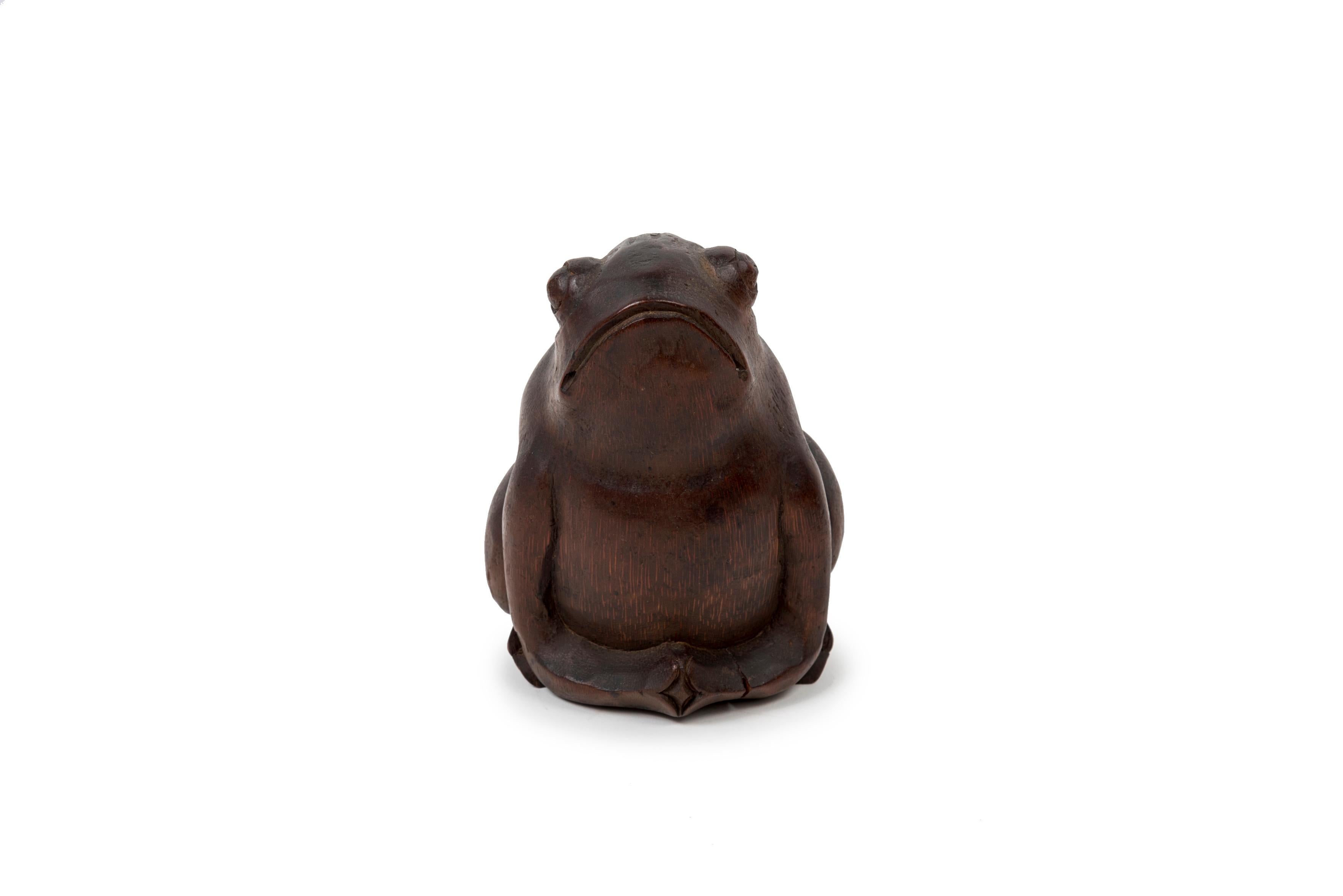 Bamboo sitting toad. The node of the wood is used as the base of the statuette.

The toad and the frog, referred to by the same term in Japanese (kaeru) are associated with good luck and wealth. Kaeru means both 