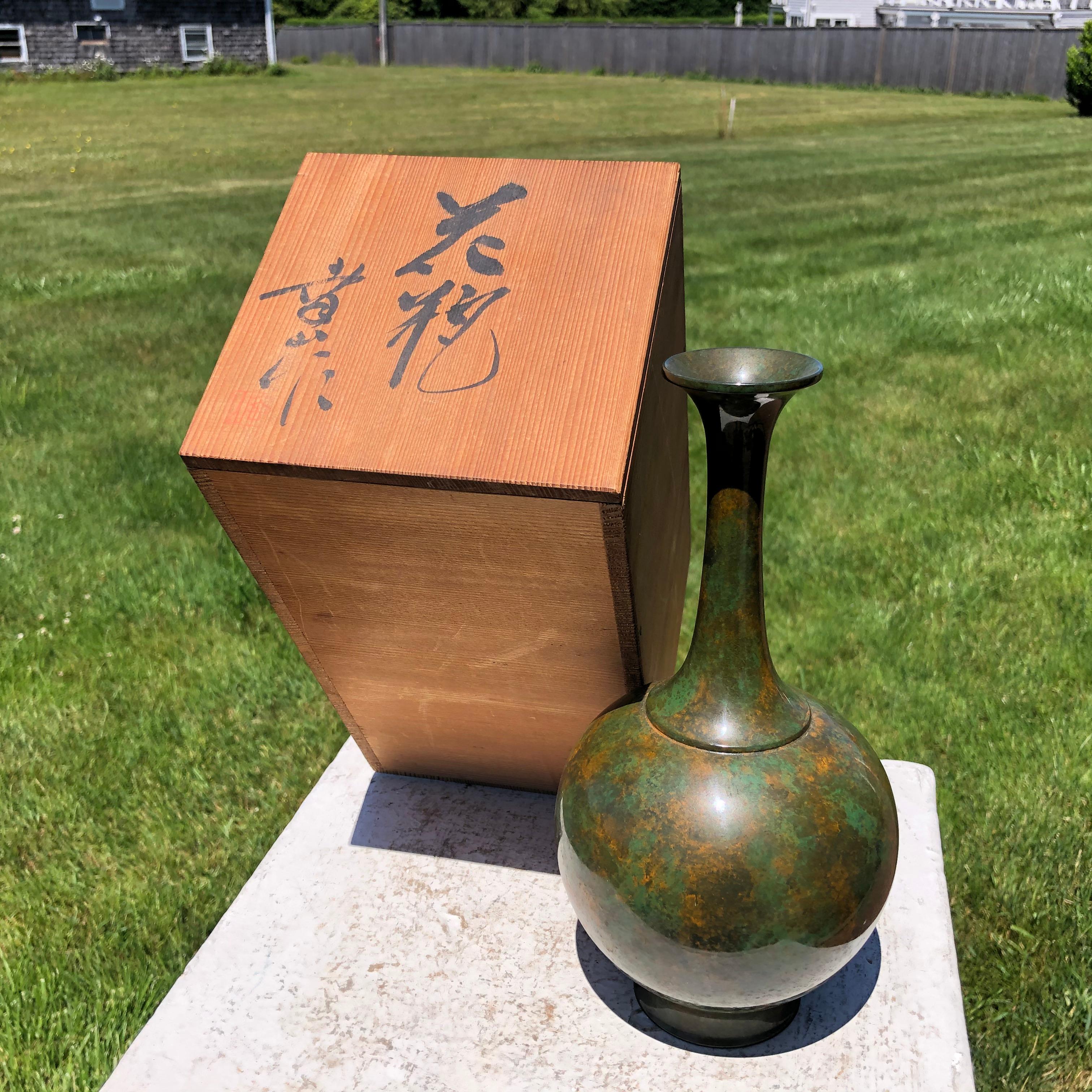 Stunning example

Take a good look at the exceptional green glaze with orange highlights on this bronze vase. It is very fine. 

In virtually mint condition it is signed on its base and is accompanied by its original signed collector hinoki wood