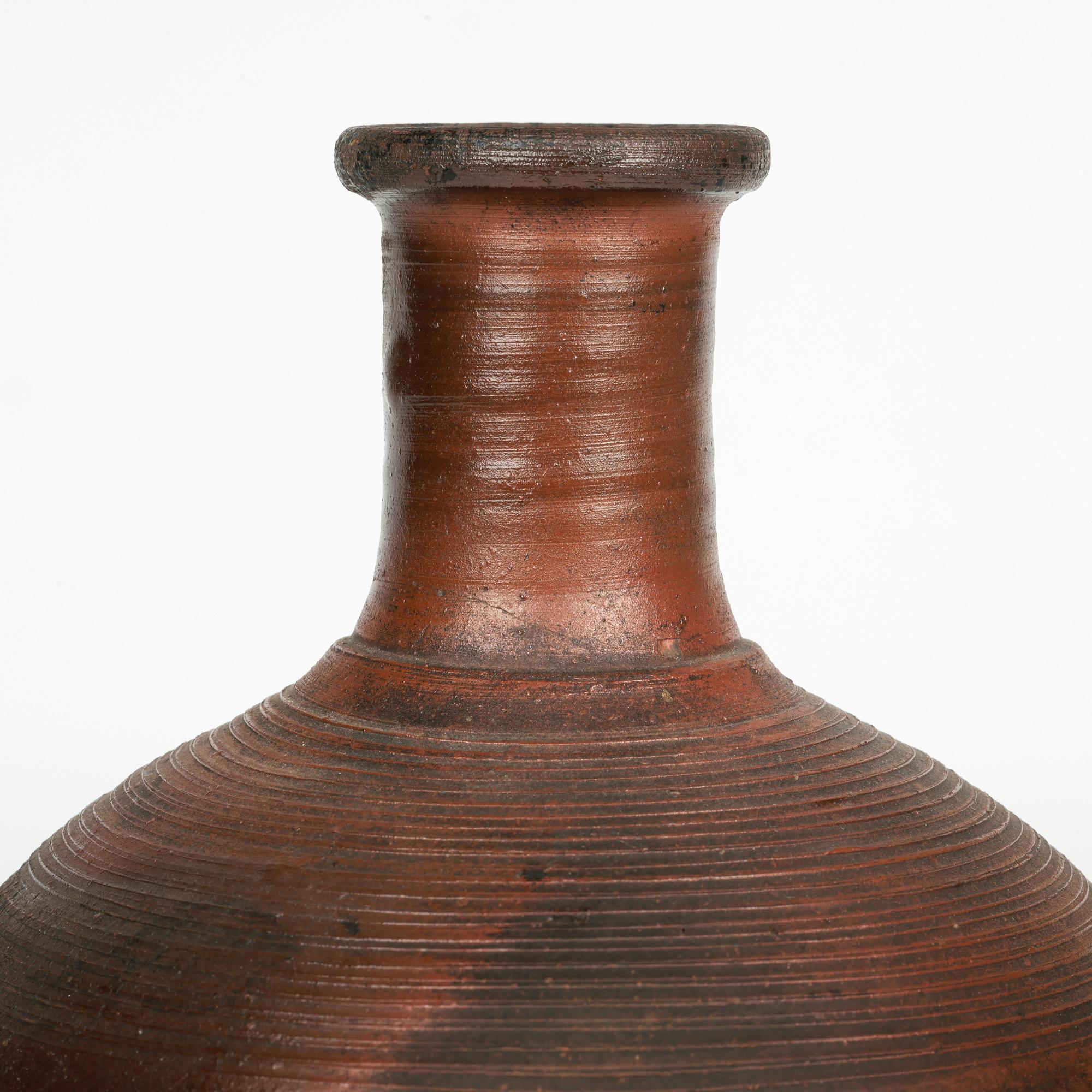 A very stylish antique Japanese Bizen ware art pottery vase set with figures and dating from the 19th century. The stoneware vase is hand-thrown from a red colored clay which has been high fired to give an almost burnt effect to the finish. The vase