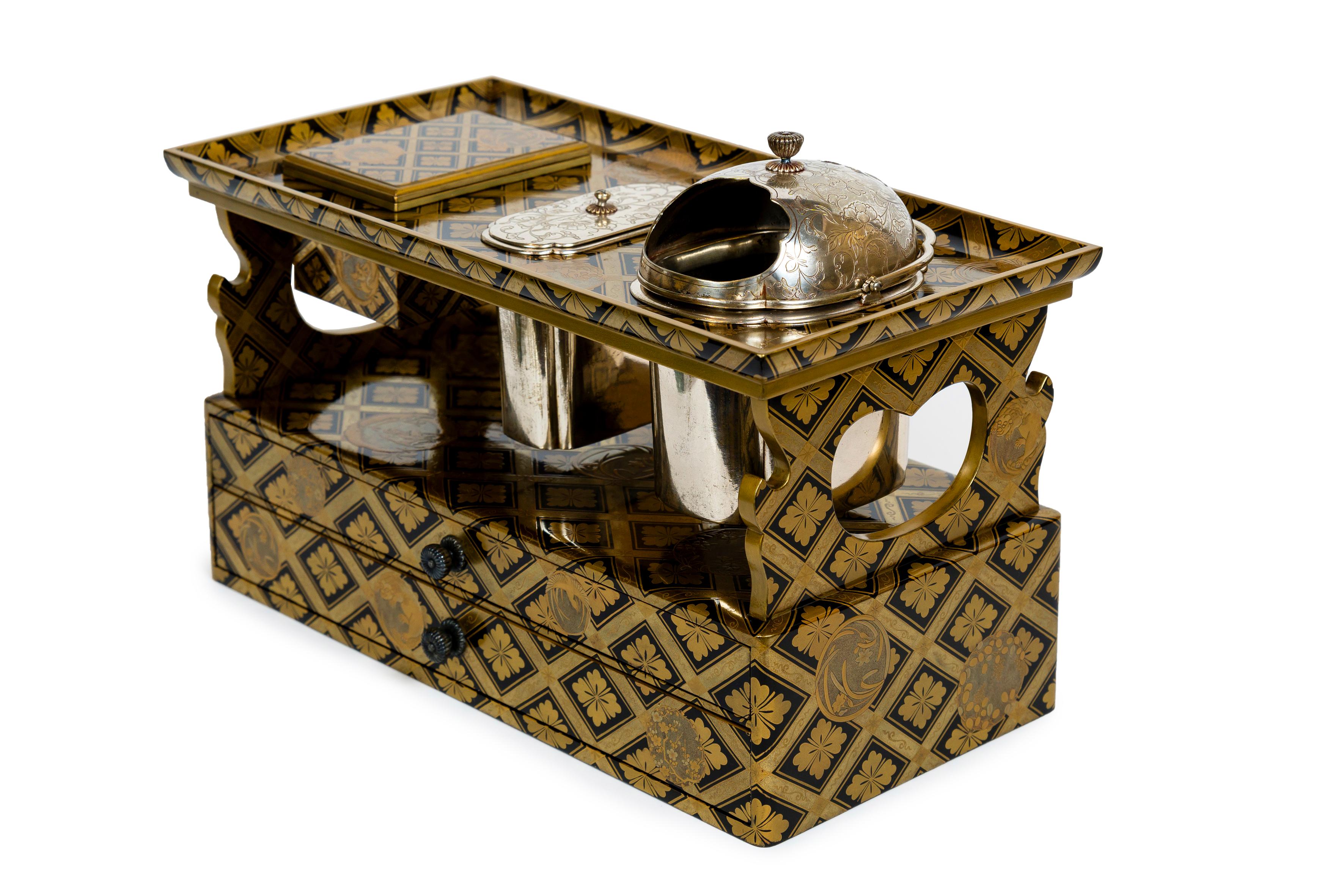Tabako Bon, or tobacco smoking set, adorned with gold and black fundame lacquer, in the form of cross braces and floret of the Hanabishi flower. The regular pattern is dotted with circular lockets representing flowers, birds, lions and dragons. 
The