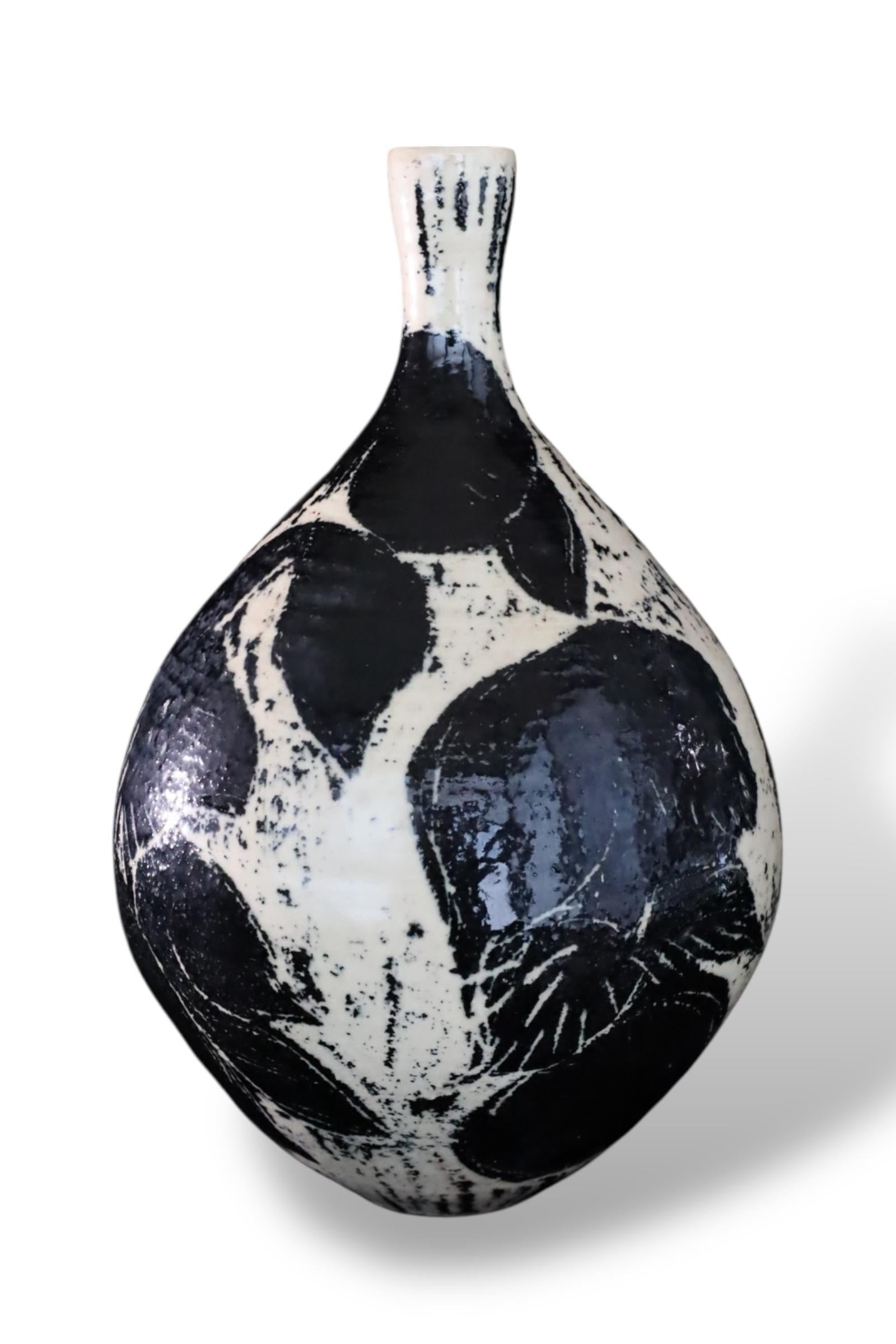 This striking ceramic vase from Japan, dating to the late 20th century, features a bold monochrome palette and a highly expressive surface. The bulbous form tapers into a narrow neck, emphasizing the elegance of its silhouette.

Executed in a rich