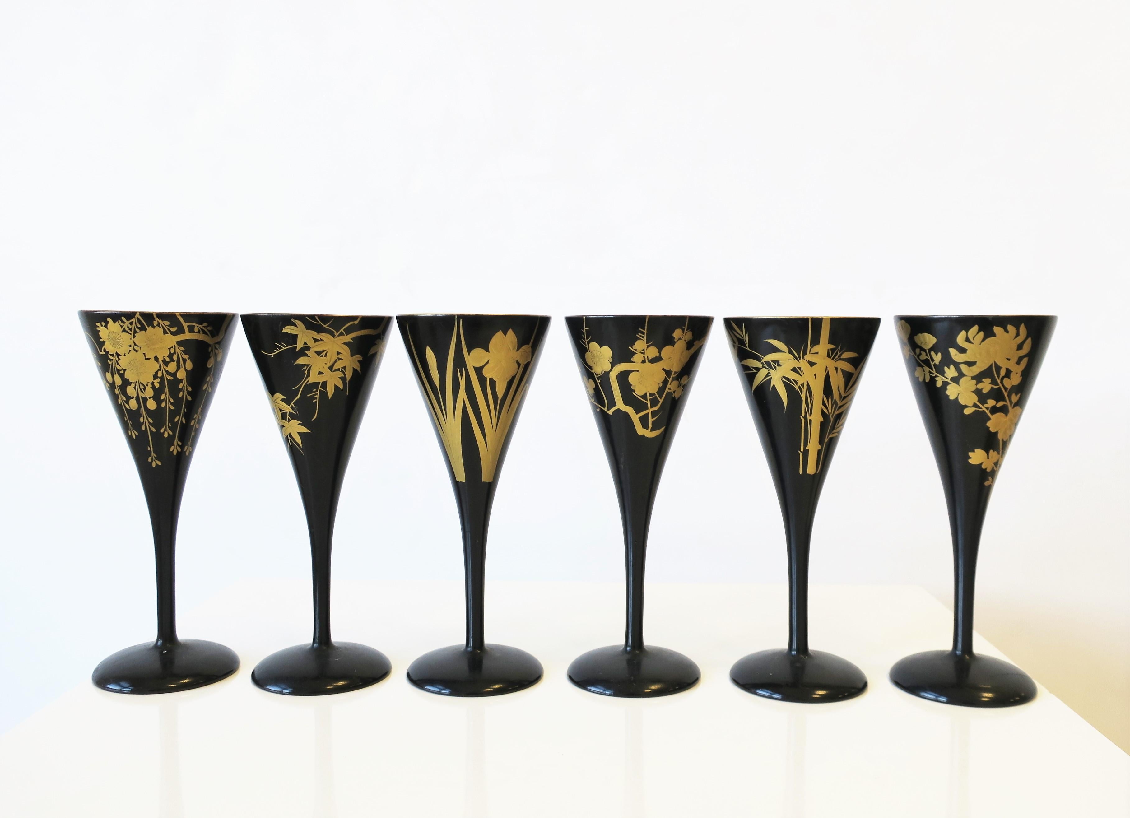 A very beautiful set of six (6) Japanese black lacquer and gold sake, Champagne flutes, or wine stemware glasses, circa 20th century, Japan. Each with a different botanical design in gold (a slightly raised relief.) Dimensions: 2.5