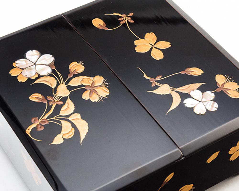 Japanese black lacquer box with maki-e lacquer floral design of sakura (cherry blossom) Edo period. 

With a contrasting interior lacquer finish of warm dark caramel, and exterior floral embellishment in gold and mother-of-pearl , this charming